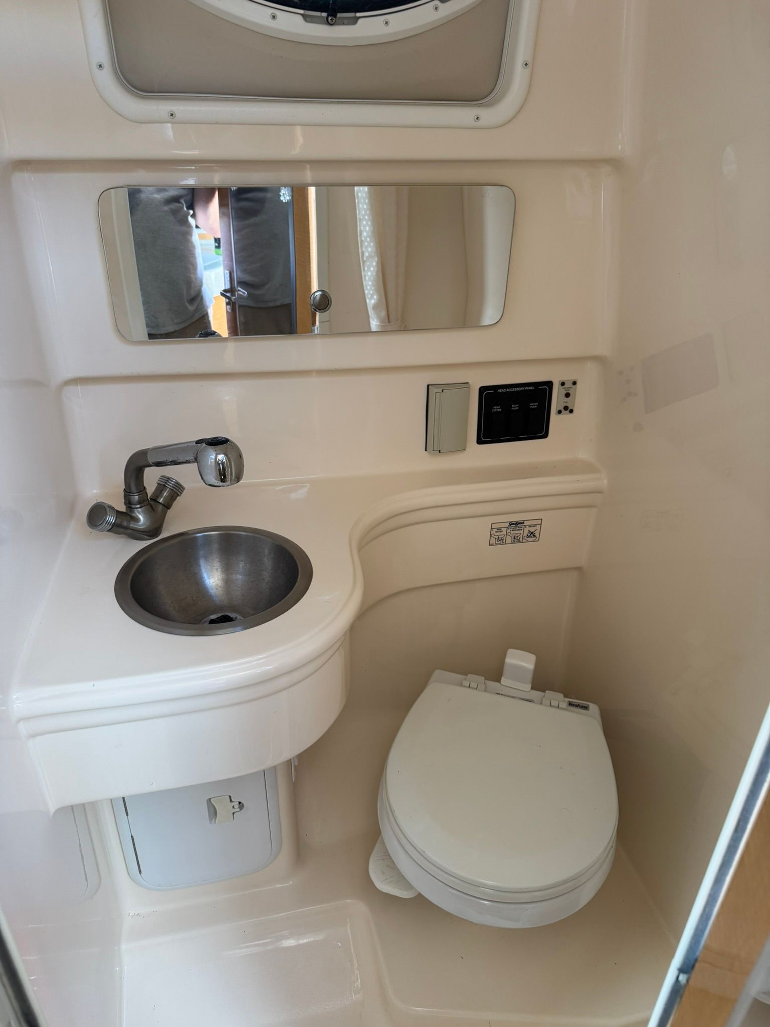 Interior of a boat cabin with a sink and toilet.