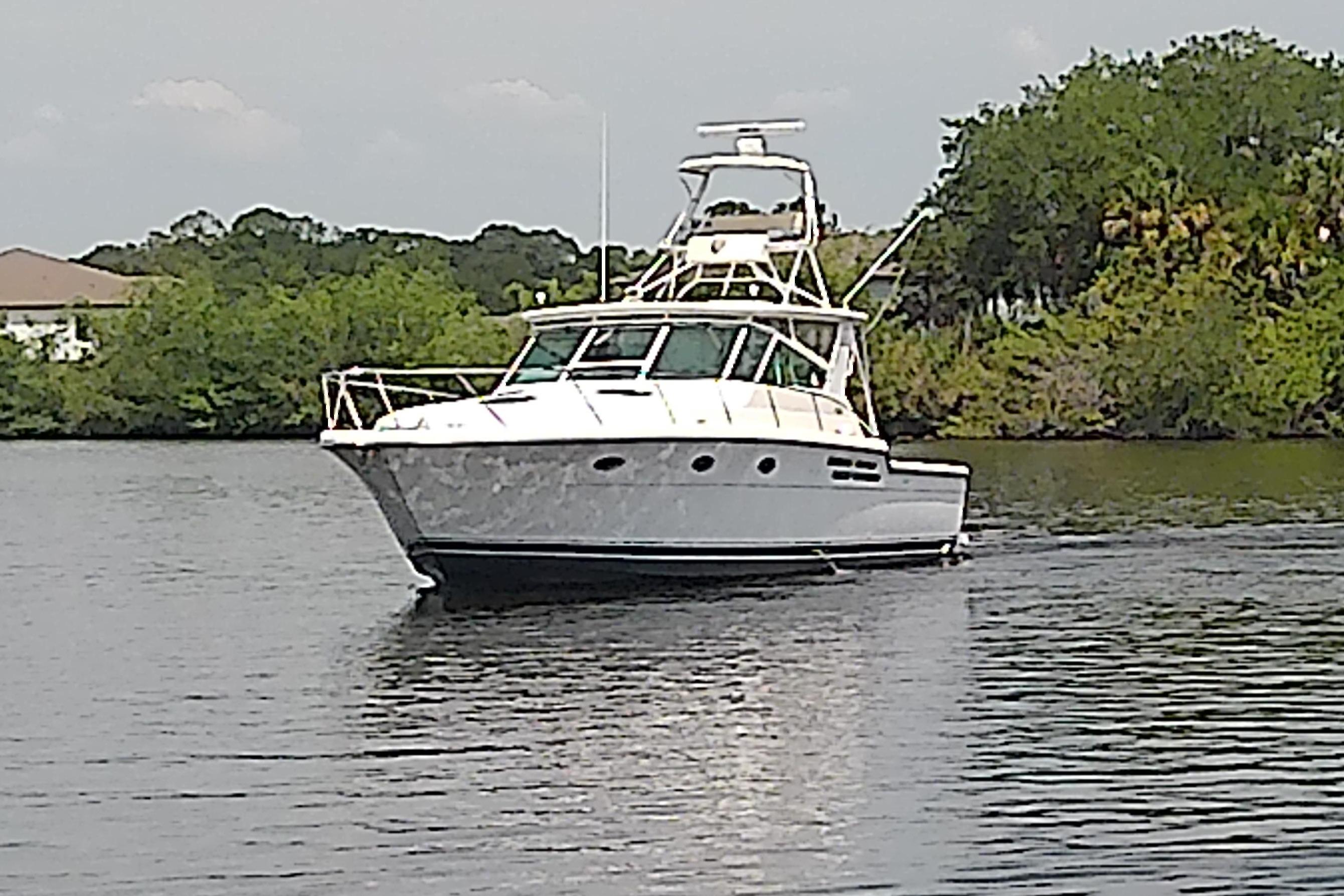 2000 Tiara Yachts 4100 Open cruising on a calm river with lush greenery.