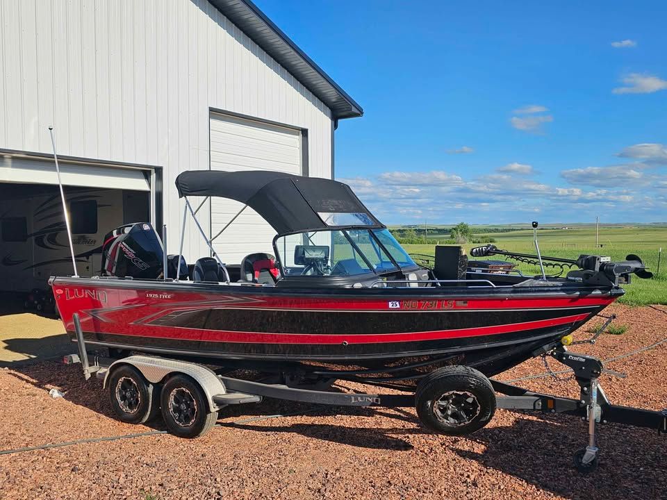 2020 Lund 1975 Tyee boat parked outside garage on sunny day.