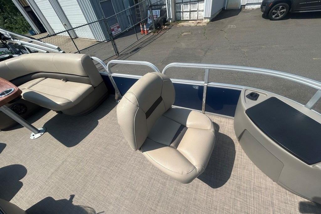 2023 Sun Tracker Bass Buggy 18 DLX pontoon boat interior with beige seating and carpeted floor.
