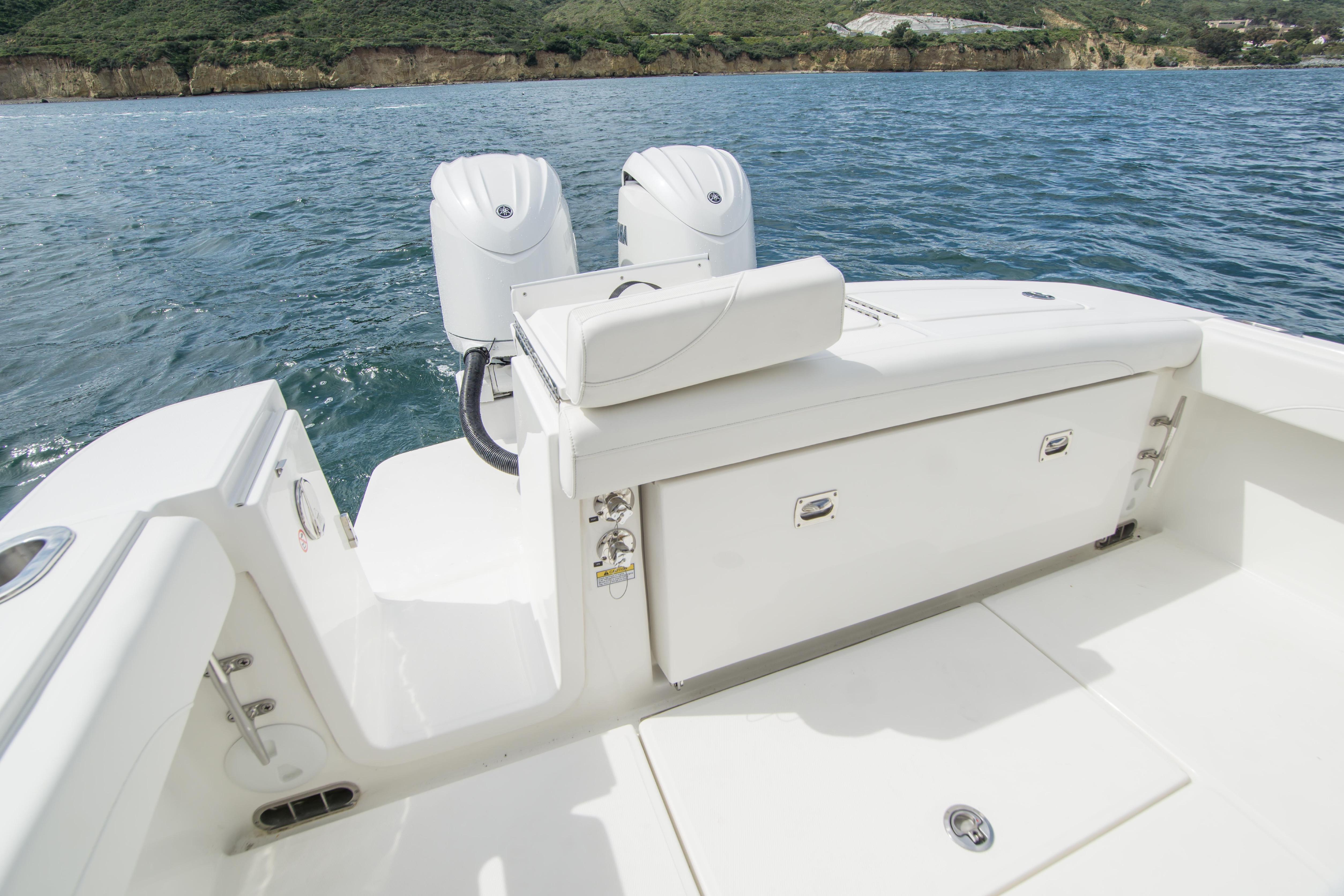 2026 Regulator 23 boat with dual engines on calm water, scenic coastline in background.