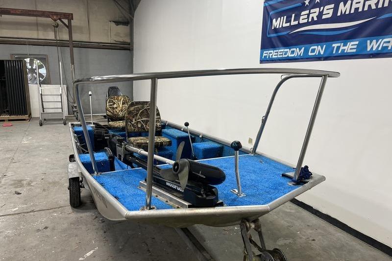 2006 SCANDY WHITE 1310 boat with blue interior and camo seats in a garage.