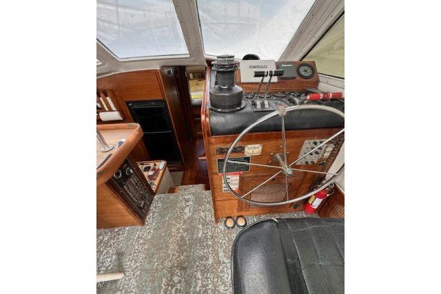 Interior view of 1982 Lancer 45 Motorsailer cockpit with steering wheel and navigation equipment.
