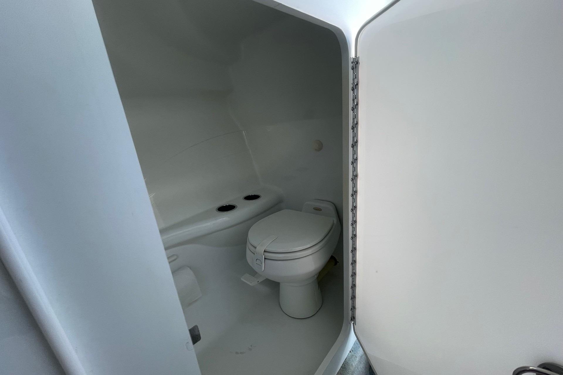 2004 Formula 382 FASTech boat bathroom interior with white toilet and compact design.