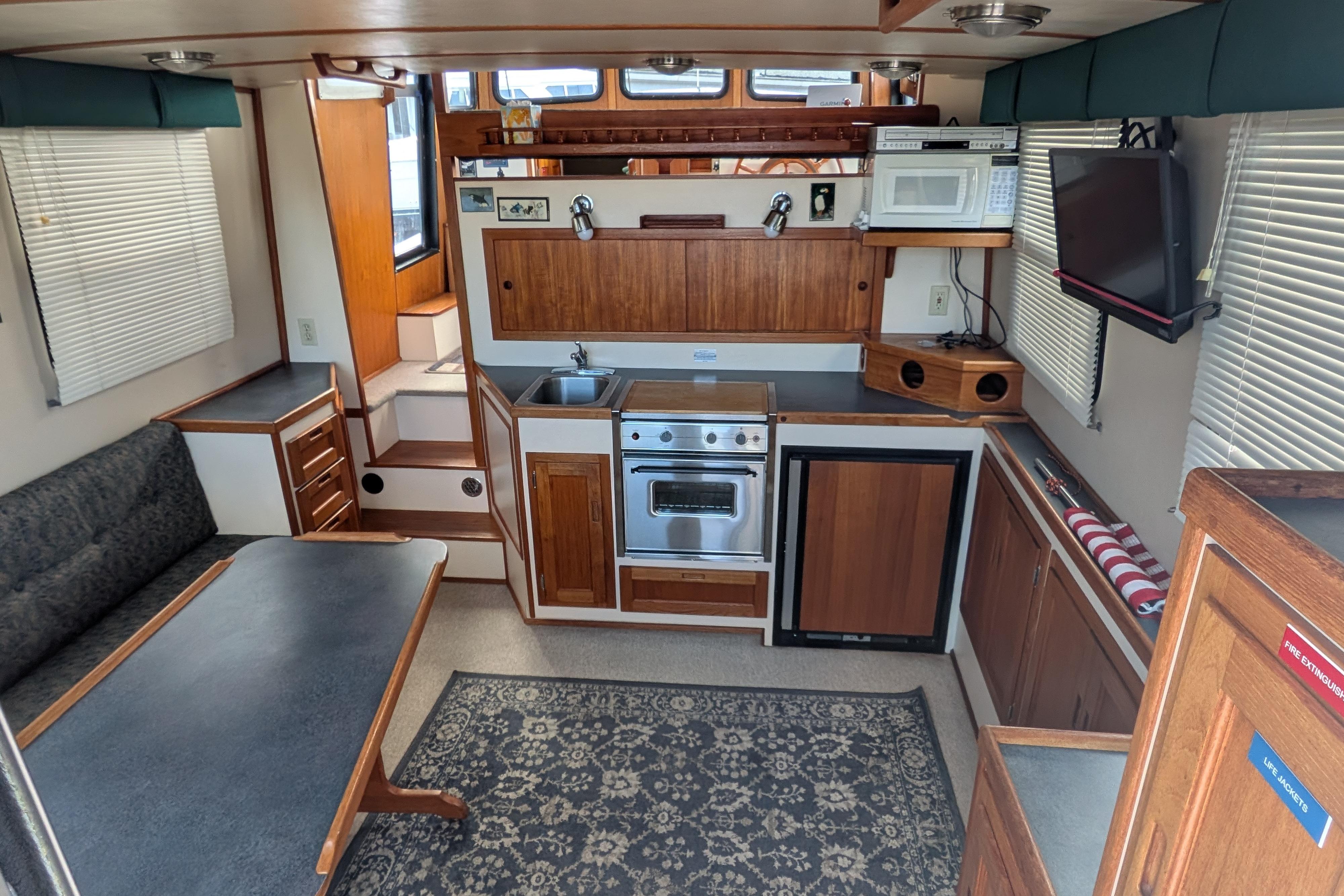 Interior of a 1998 Nordic Tug 32, featuring a compact kitchen and dining area.