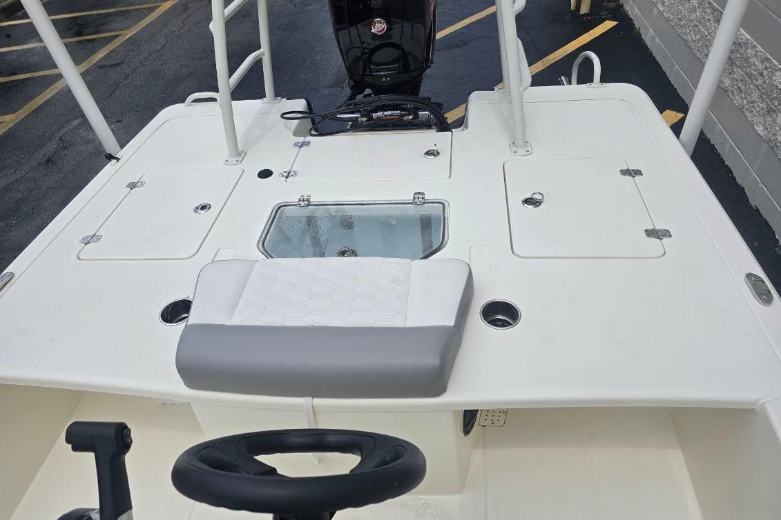 2026 Mako 18 Pro Skiff boat interior with steering wheel and storage compartments.