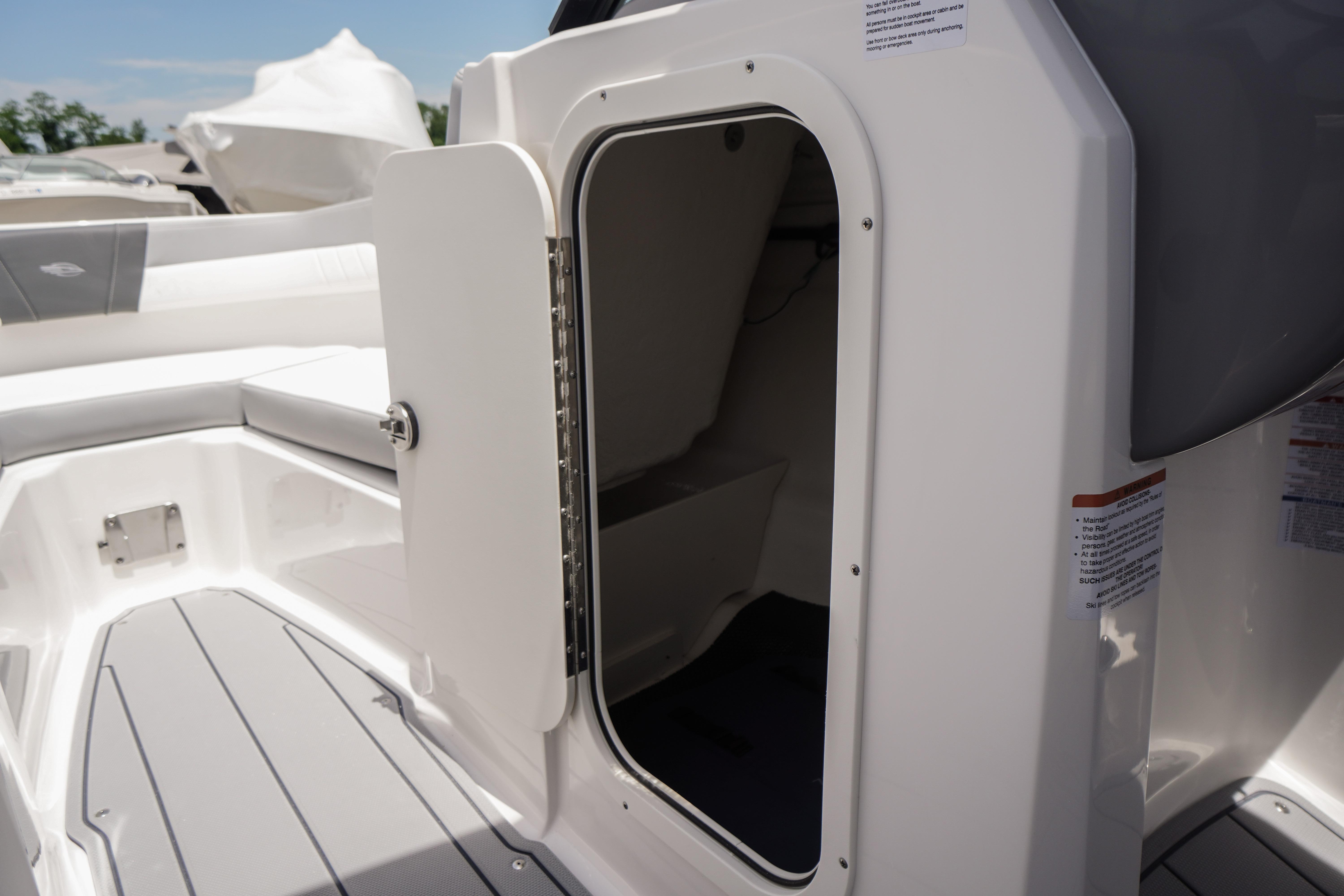 2026 Chaparral 23 SSi OB boat interior with open storage compartment and seating area.