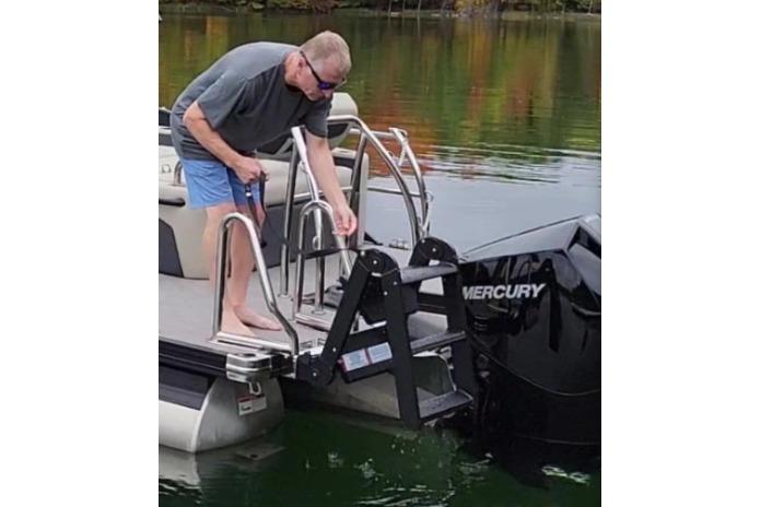Man on Lowe LS 190 boat adjusting ladder near Mercury engine, 2026 model.