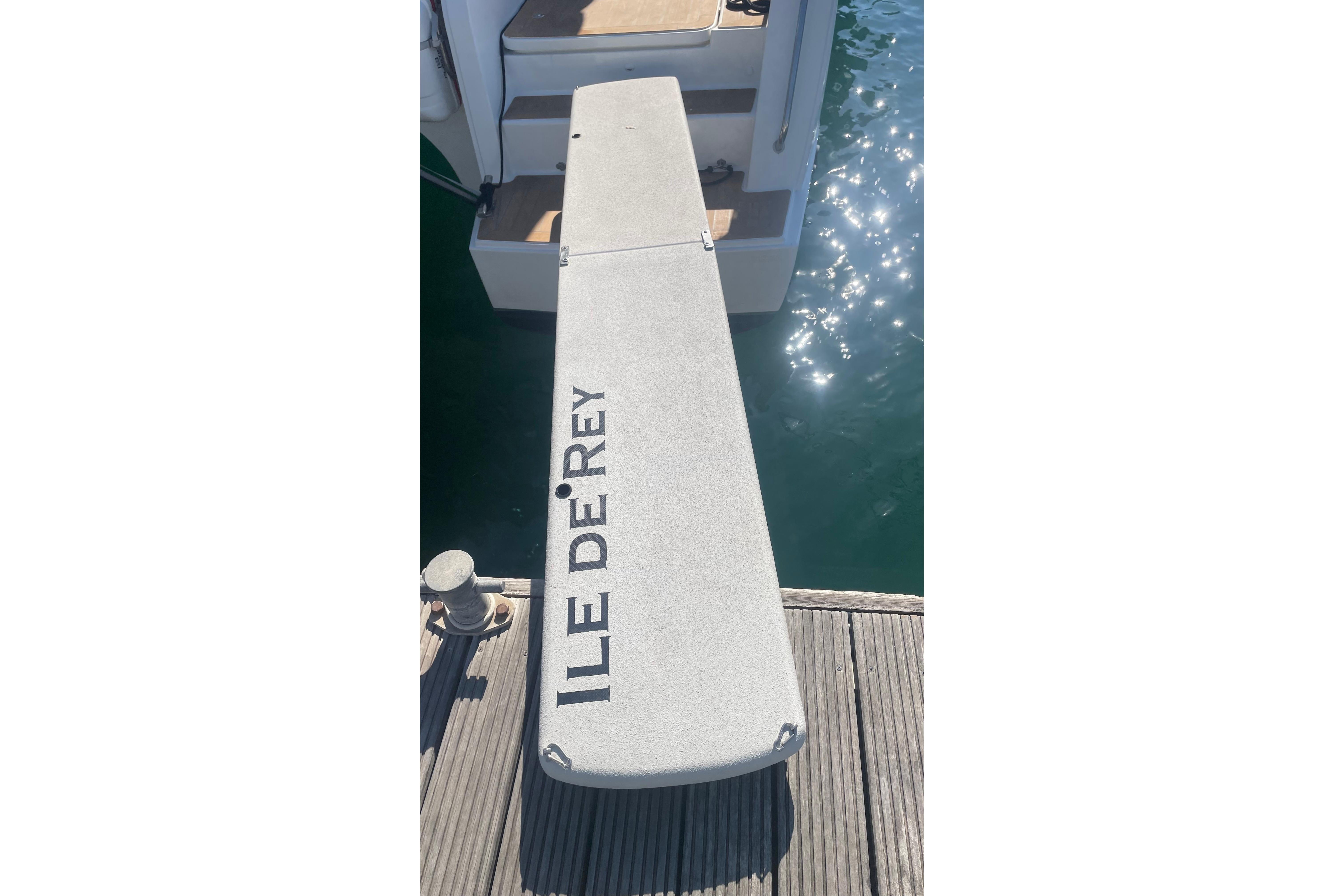 Gangway of 2020 Fountaine Pajot Saona 47 catamaran, labeled "ILE DE REY," docked by water.