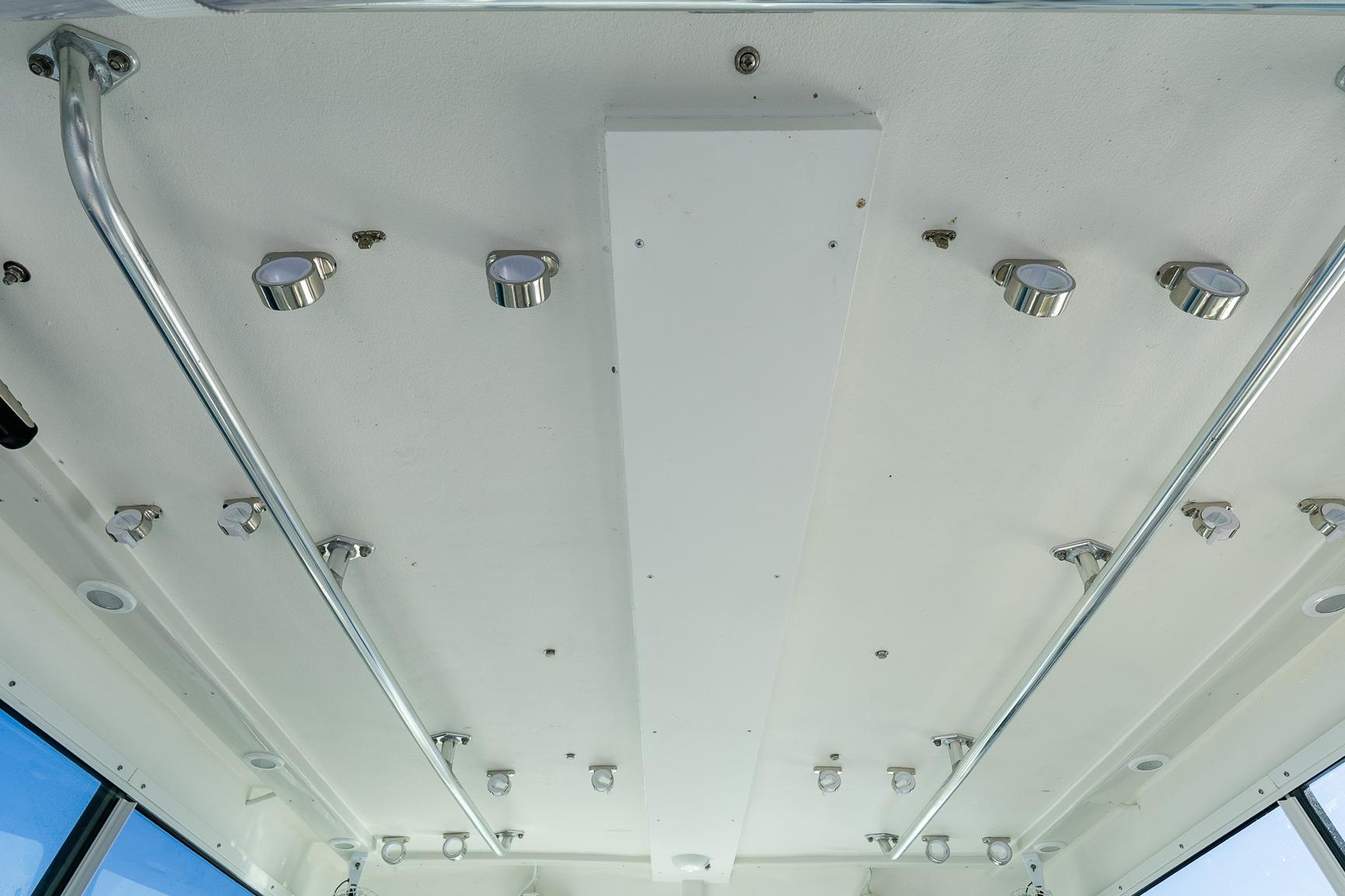 Ceiling view of 2024 Steiger Craft 31 Fisherman boat with mounted lights and metal rails.