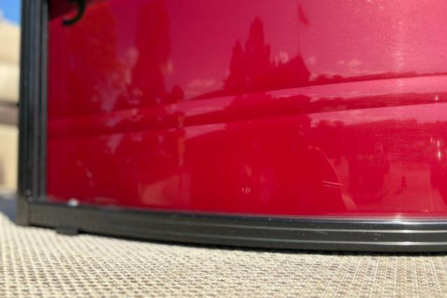Close-up of a red 2025 Regency 250 DL3 boat exterior with reflections.