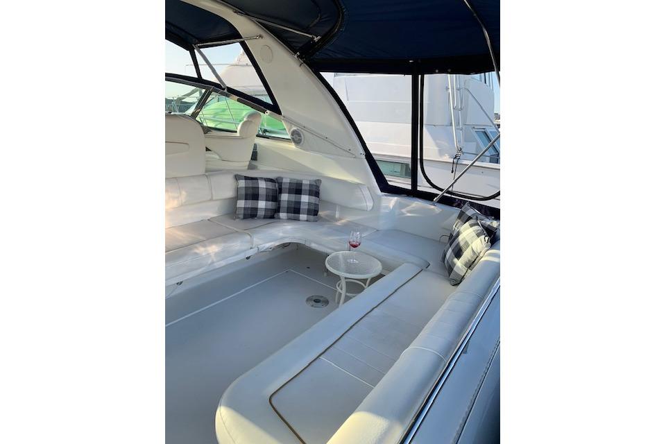 1999 Sea Ray Sundancer 400 yacht interior with white seating and plaid pillows.