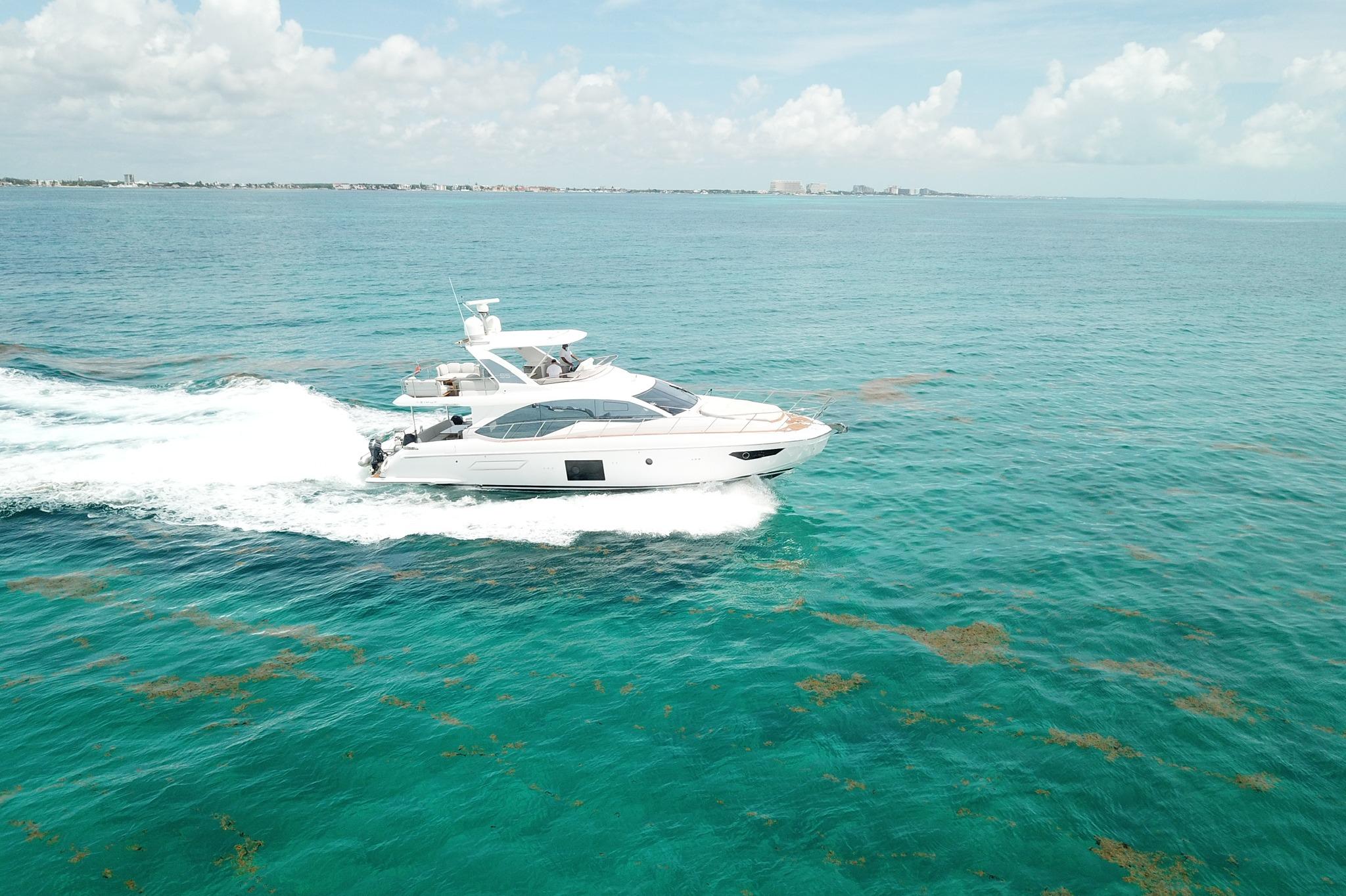 2021 Azimut 55 yacht cruising on clear turquoise ocean waters.