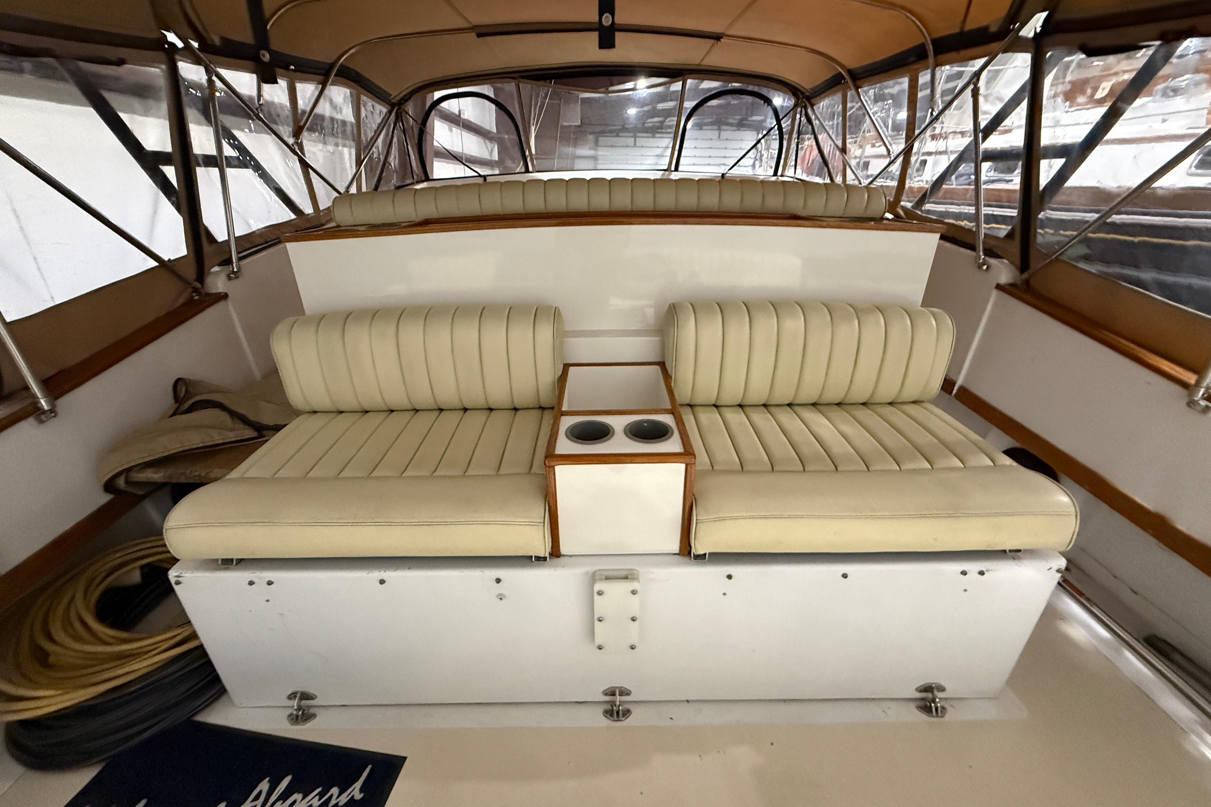 Interior of a 1979 Magnum 38 Sport boat with beige seating and cup holders.