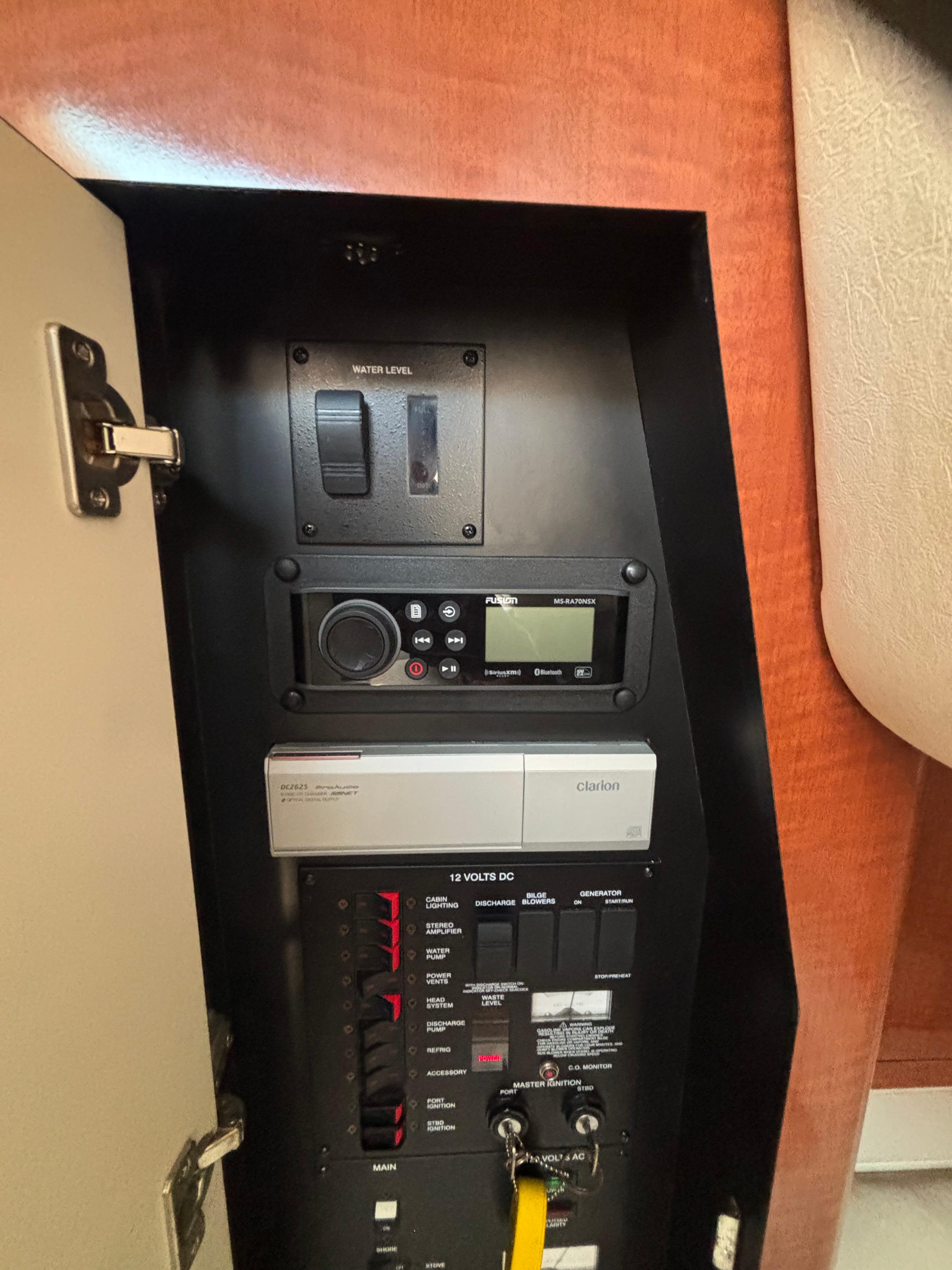 Control panel inside 2004 Sea Ray 320 Sundancer boat, featuring water level and audio system.