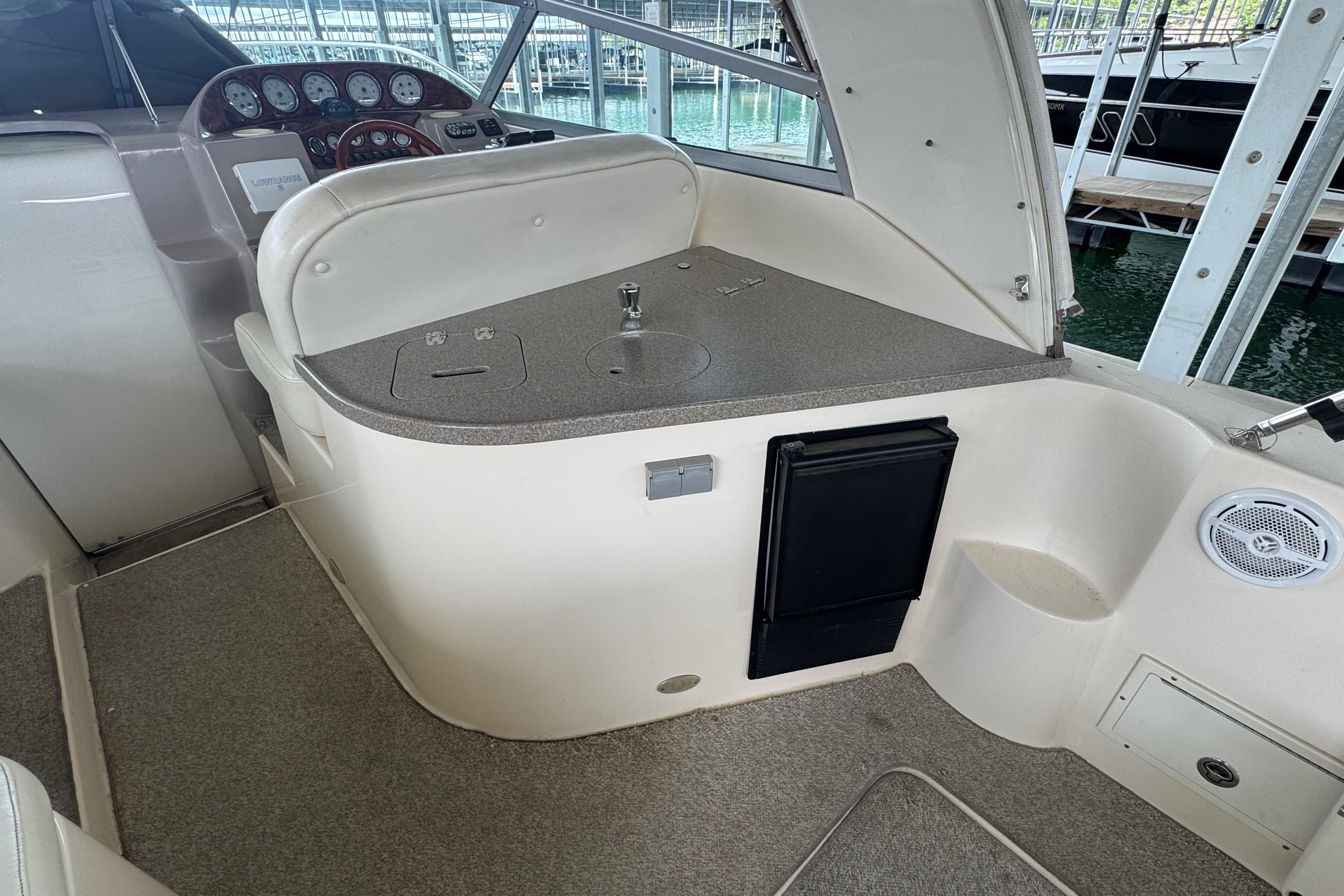 2004 Rinker Fiesta Vee 312 boat interior with helm, sink, and storage.