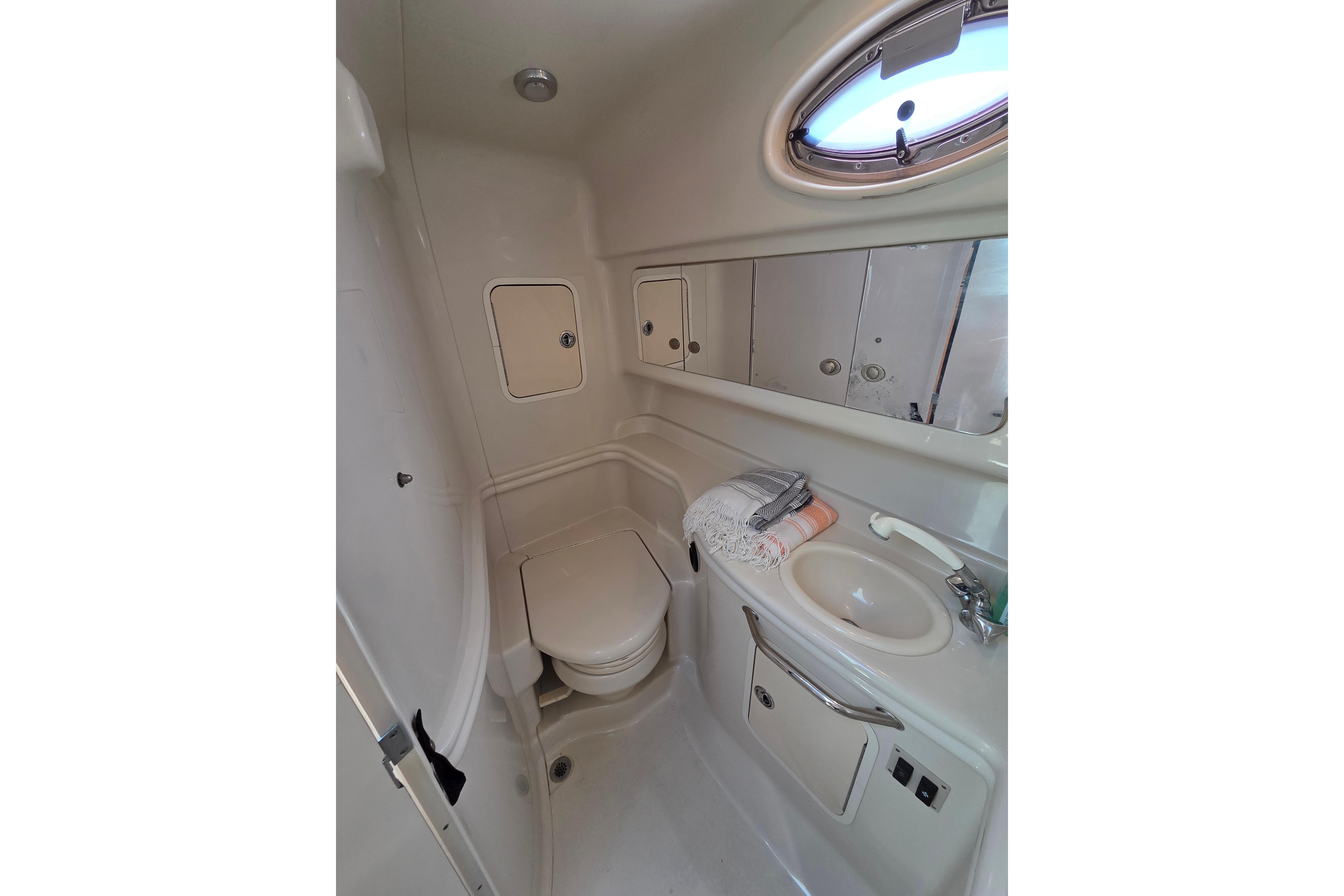 Bathroom interior of 2006 Sea Ray Sundancer 320 yacht, featuring sink and toilet.