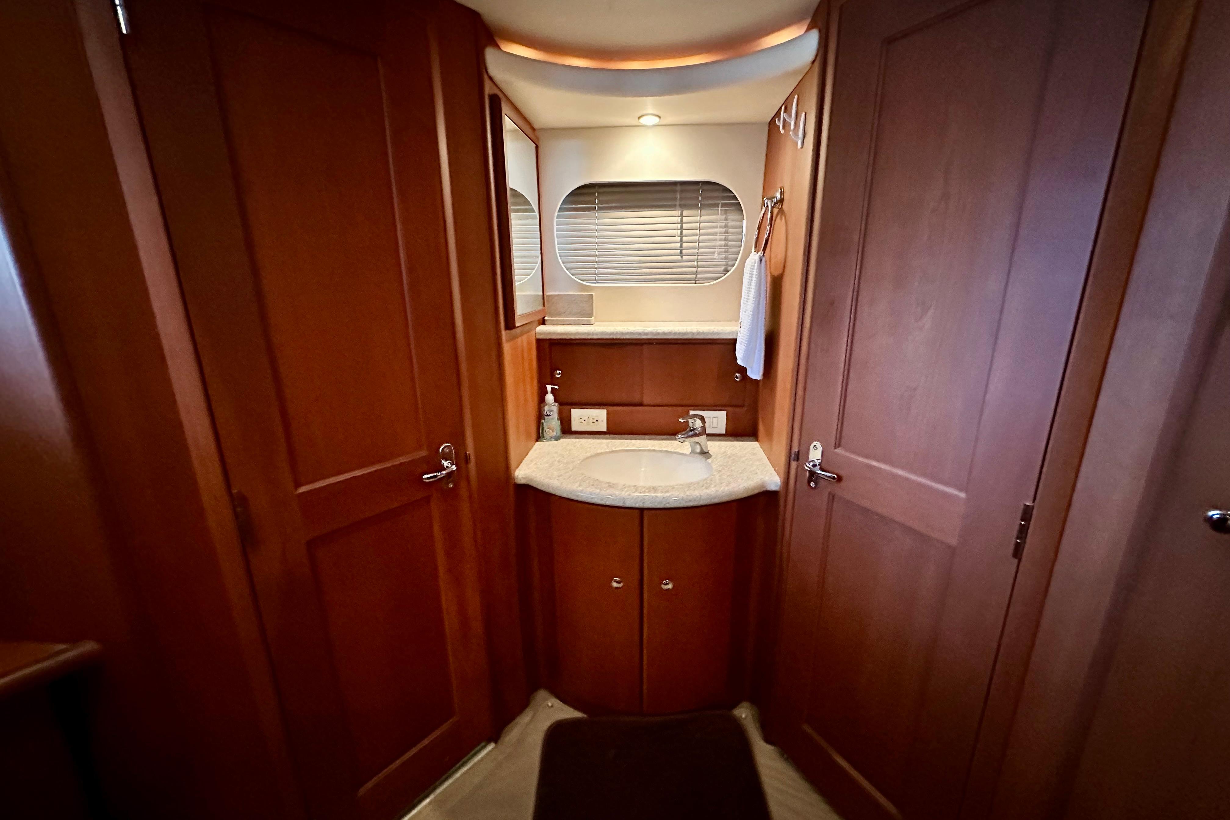 2005 Silverton 43 Motor Yacht bathroom with wooden cabinetry and modern sink.