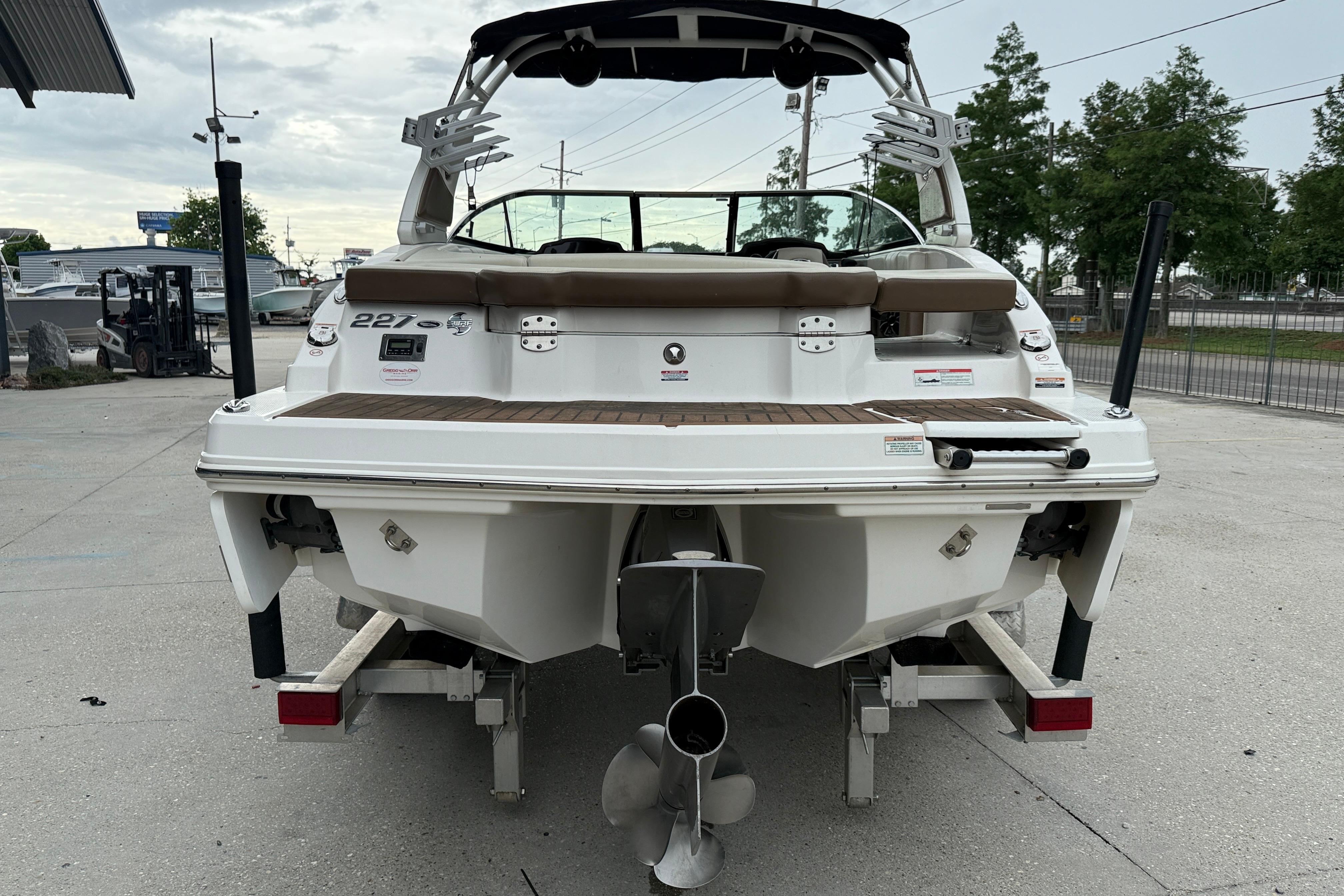 2018 Chaparral 227 SSX Surf boat, rear view, on trailer, in outdoor setting.