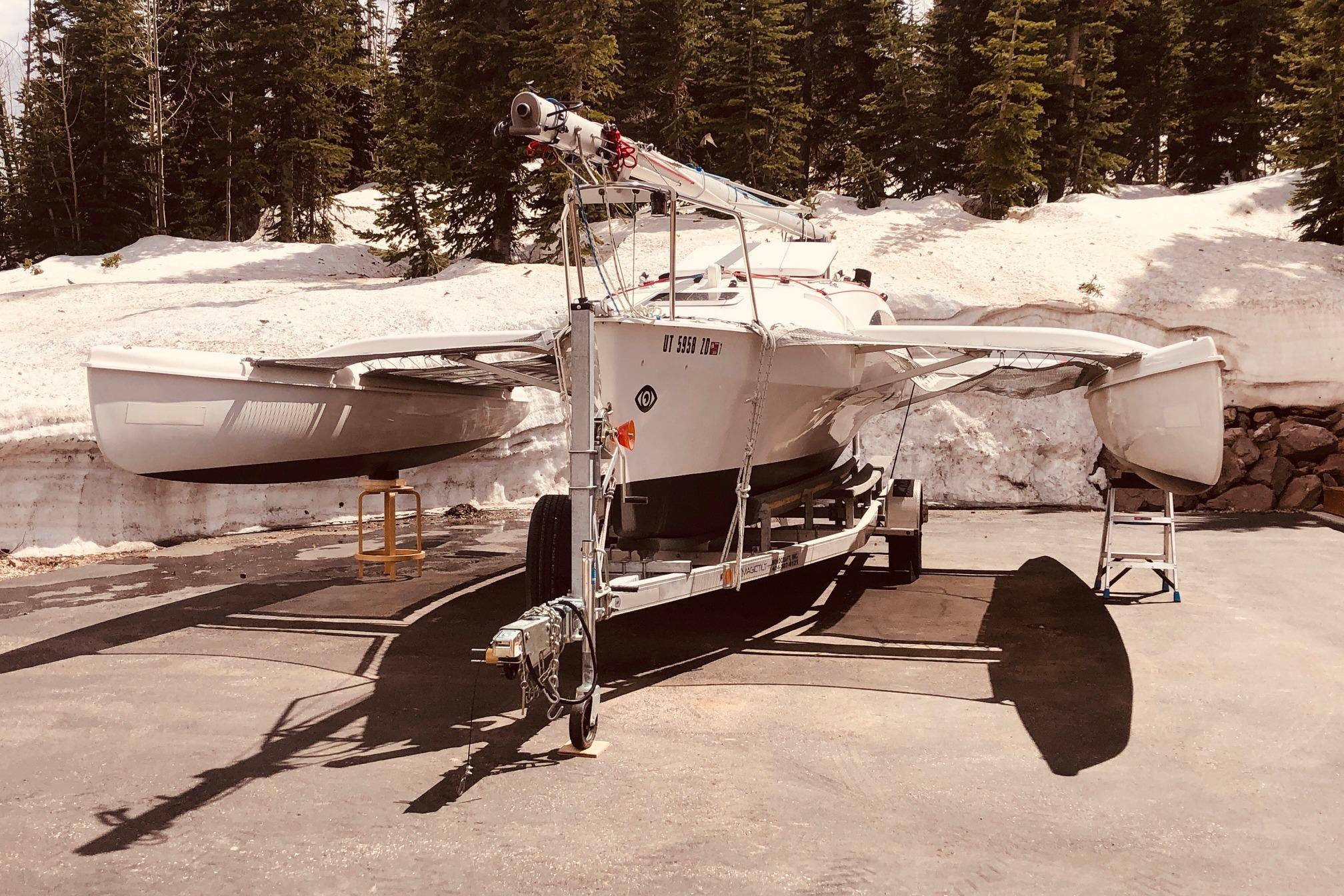 2001 Corsair F24 trimaran on trailer, surrounded by snow and trees.