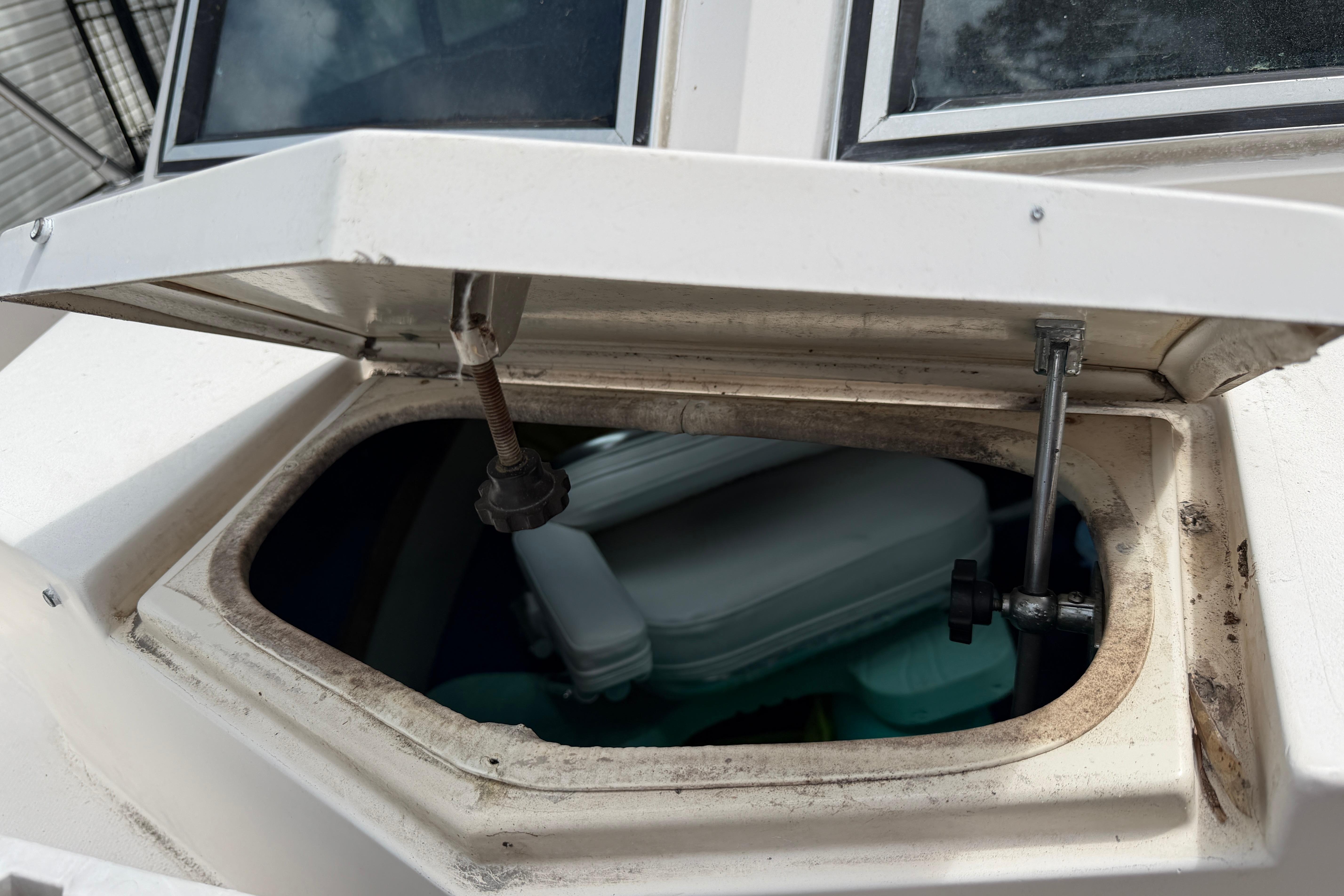 Open hatch on 1987 Grady-White Seafarer 226 boat, revealing storage compartment.