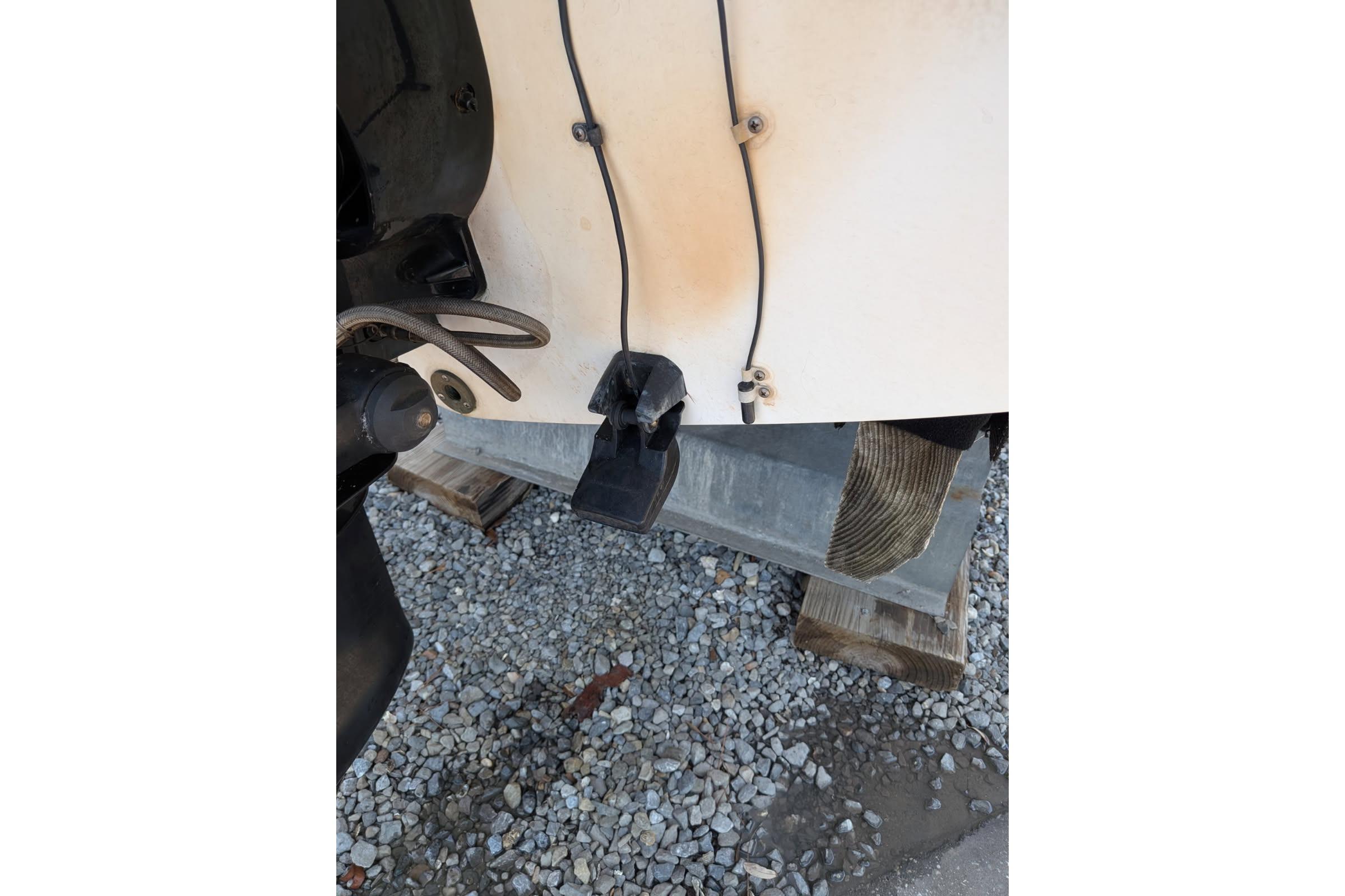 Rear view of a 2020 Cobalt 206 boat on gravel, showing engine components.