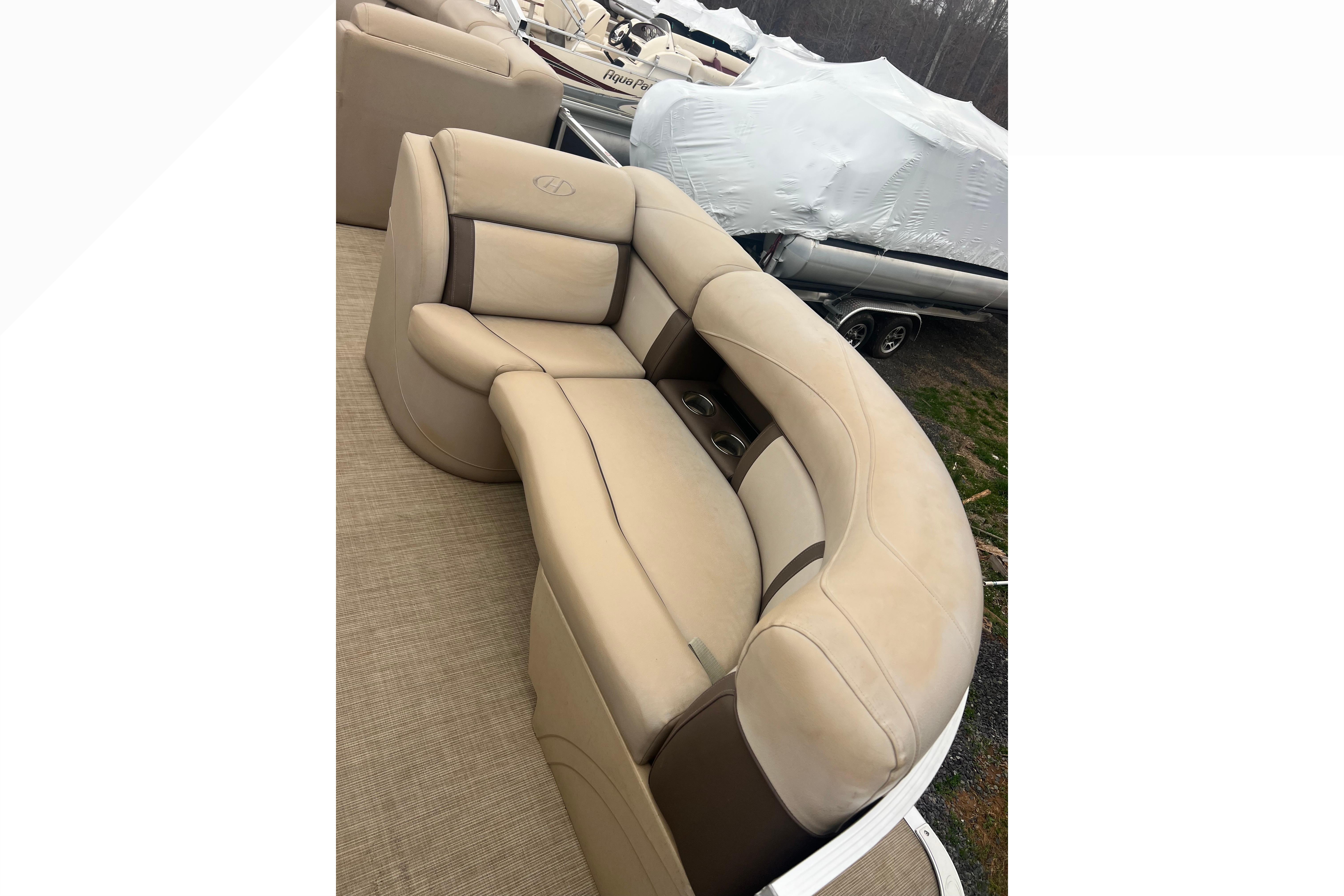 2019 Harris Cruiser 210 boat interior with beige seating and cup holders.