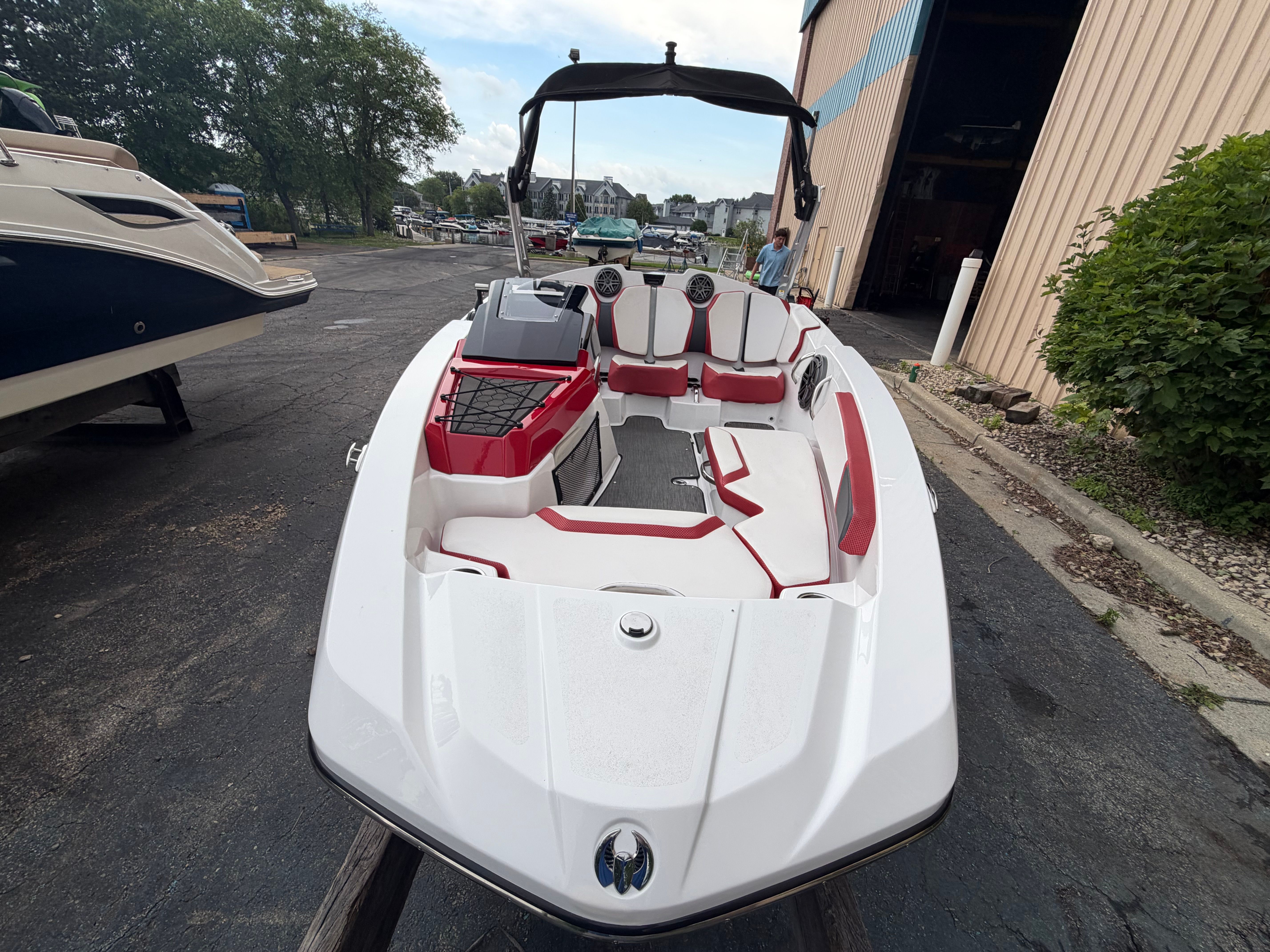 2021 Scarab 165 ID with white and red interior, parked next to a building.