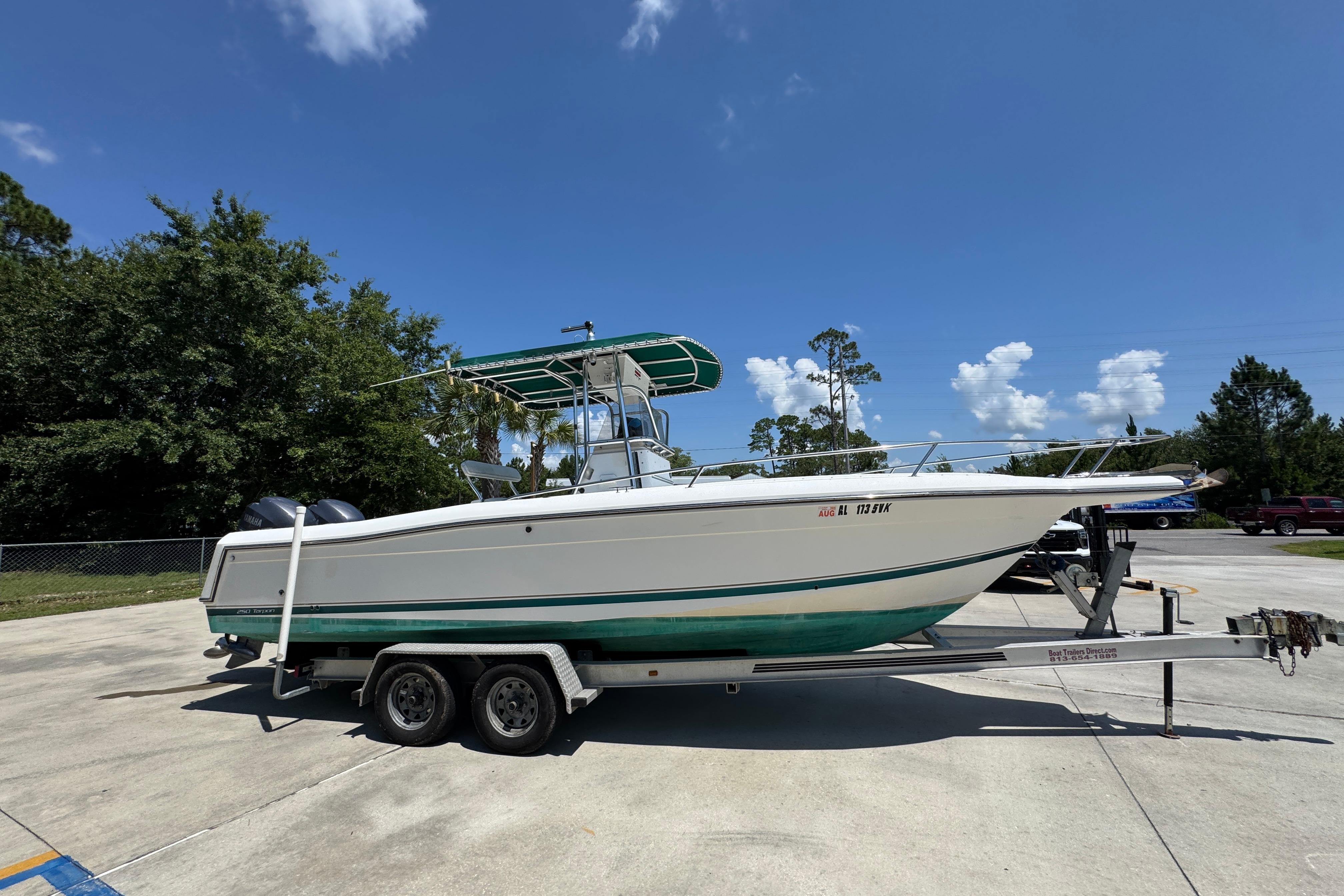 2000 Stamas 250 Tarpon boat on trailer, parked outdoors under clear blue sky.