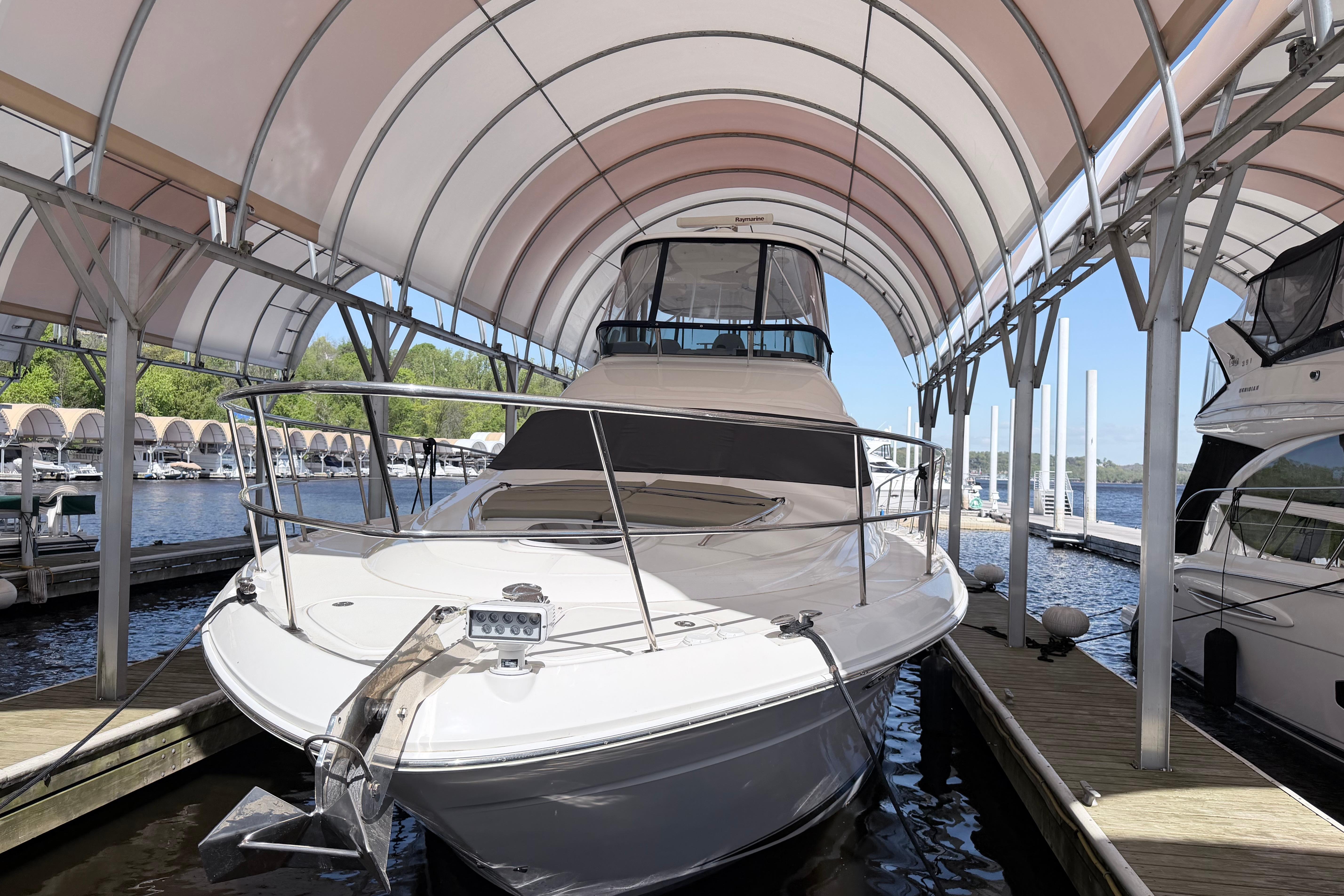 2006 Sea Ray 52 Sedan Bridge yacht docked under a canopy at a marina.