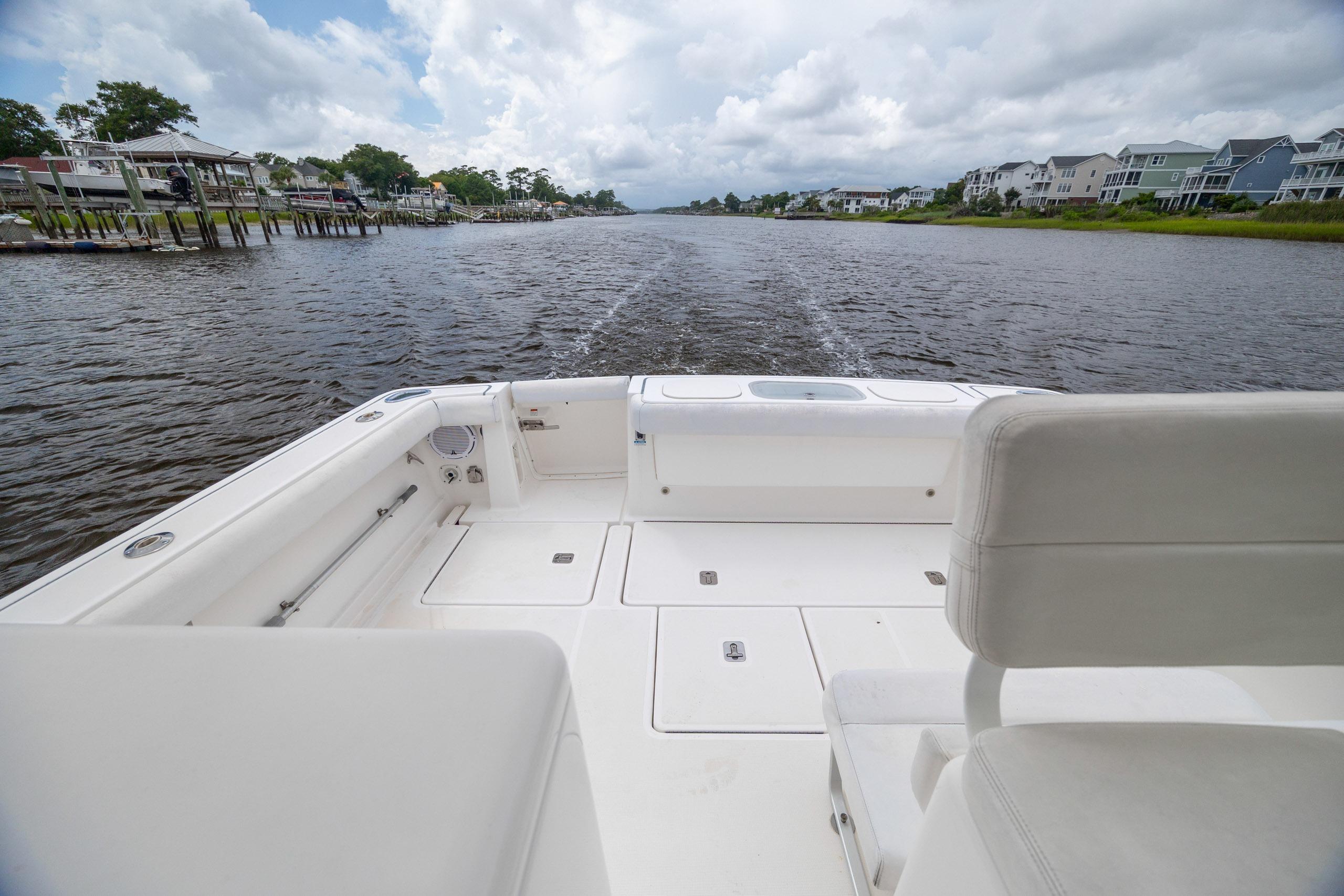 Tiara Yachts 3200 Open 2004 cruising on a scenic river with waterfront homes.