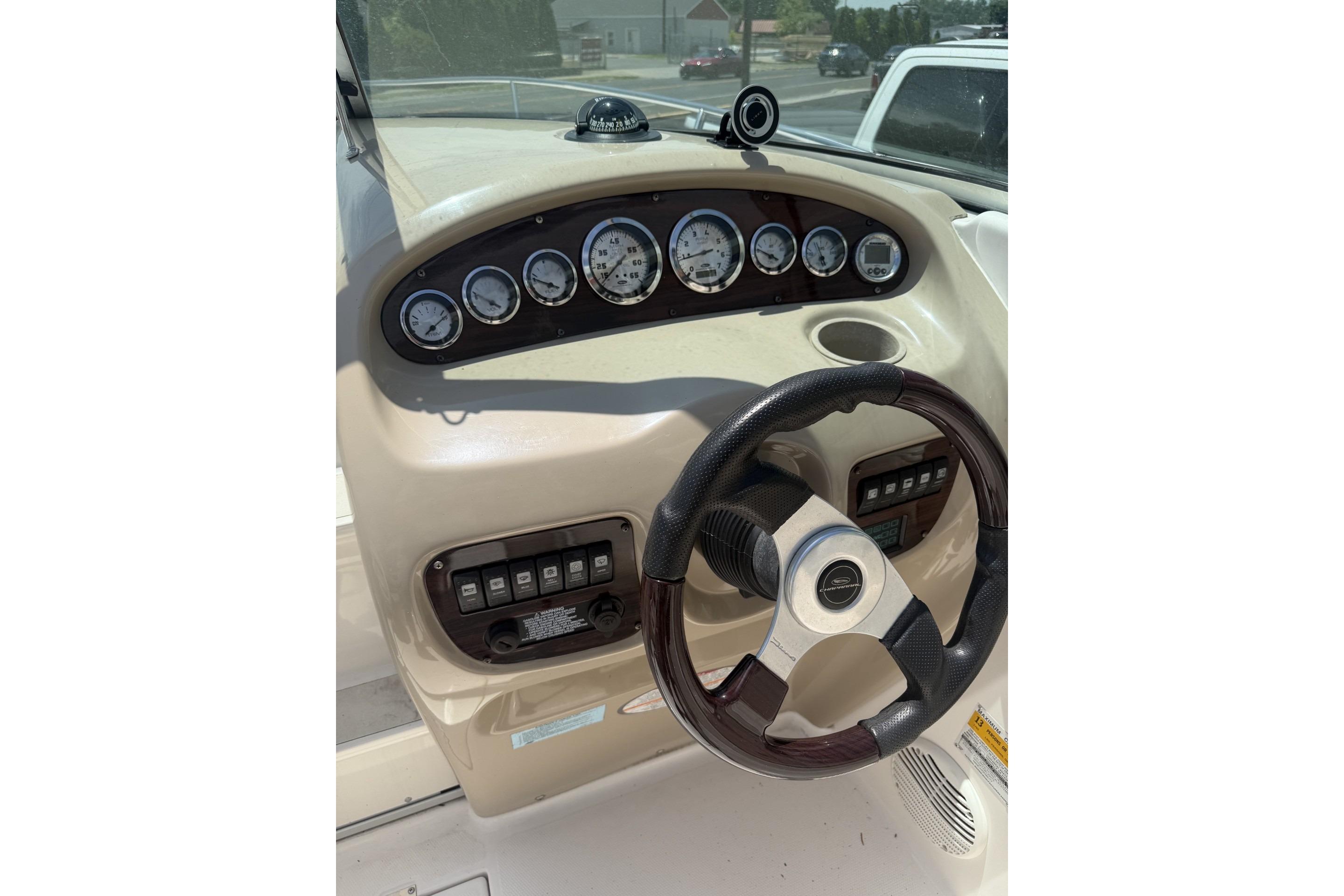 Dashboard of a 2001 Chaparral 235 SSi boat with steering wheel and gauges.