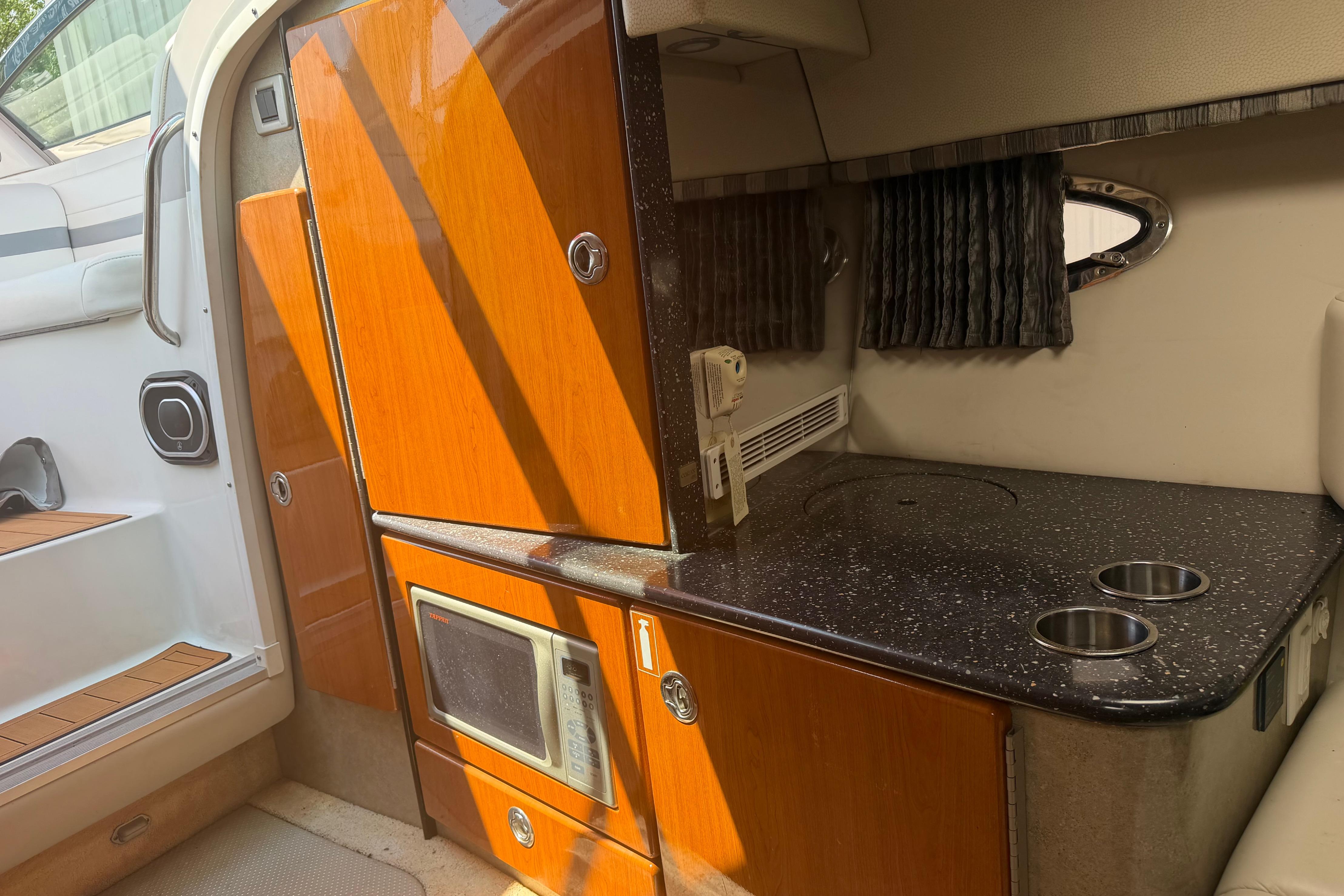 2006 Formula 330 Sun Sport cabin interior with kitchenette and wooden cabinetry.
