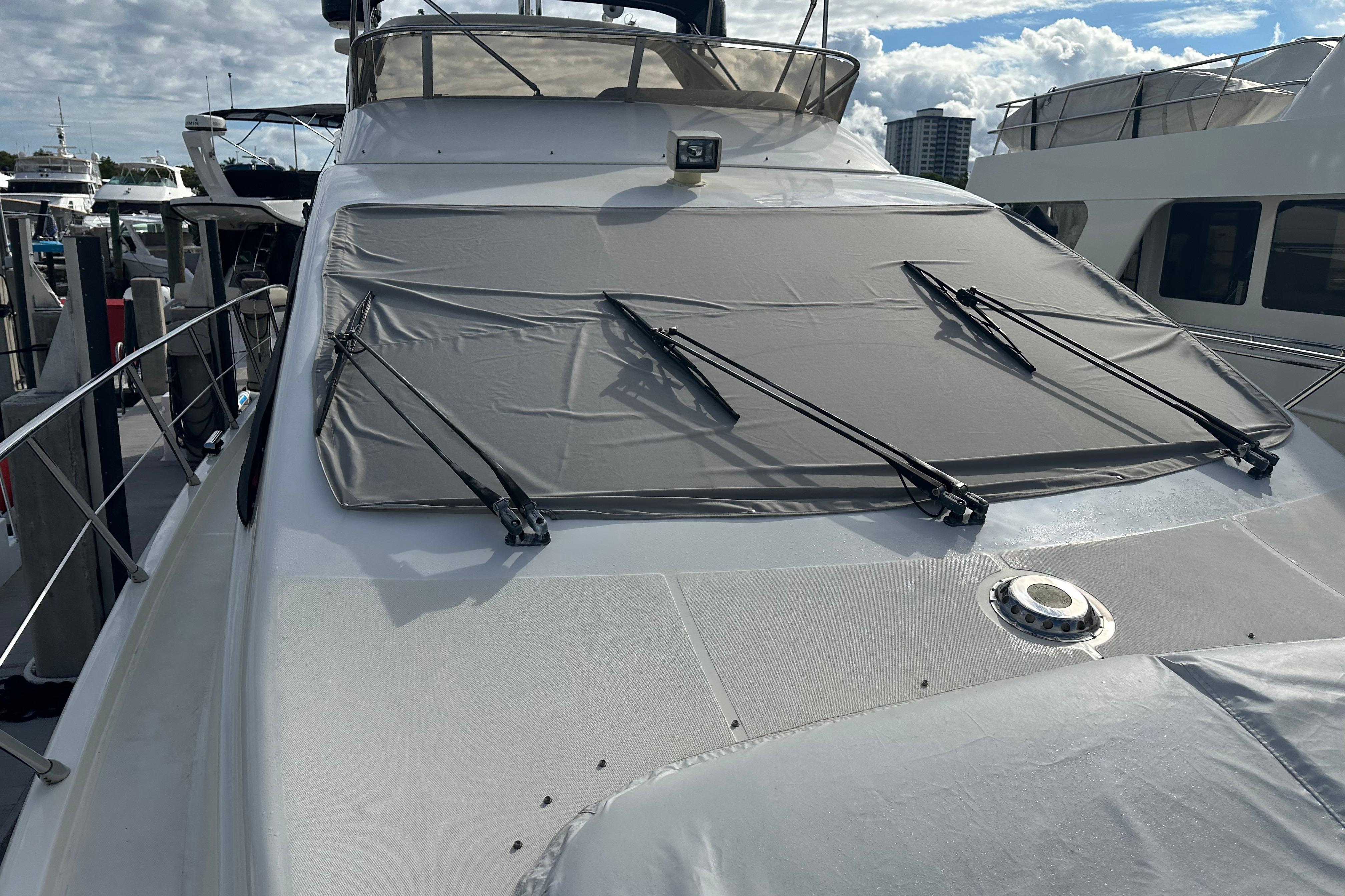 2004 Azimut 55E yacht with covered windshield and docked in a marina.