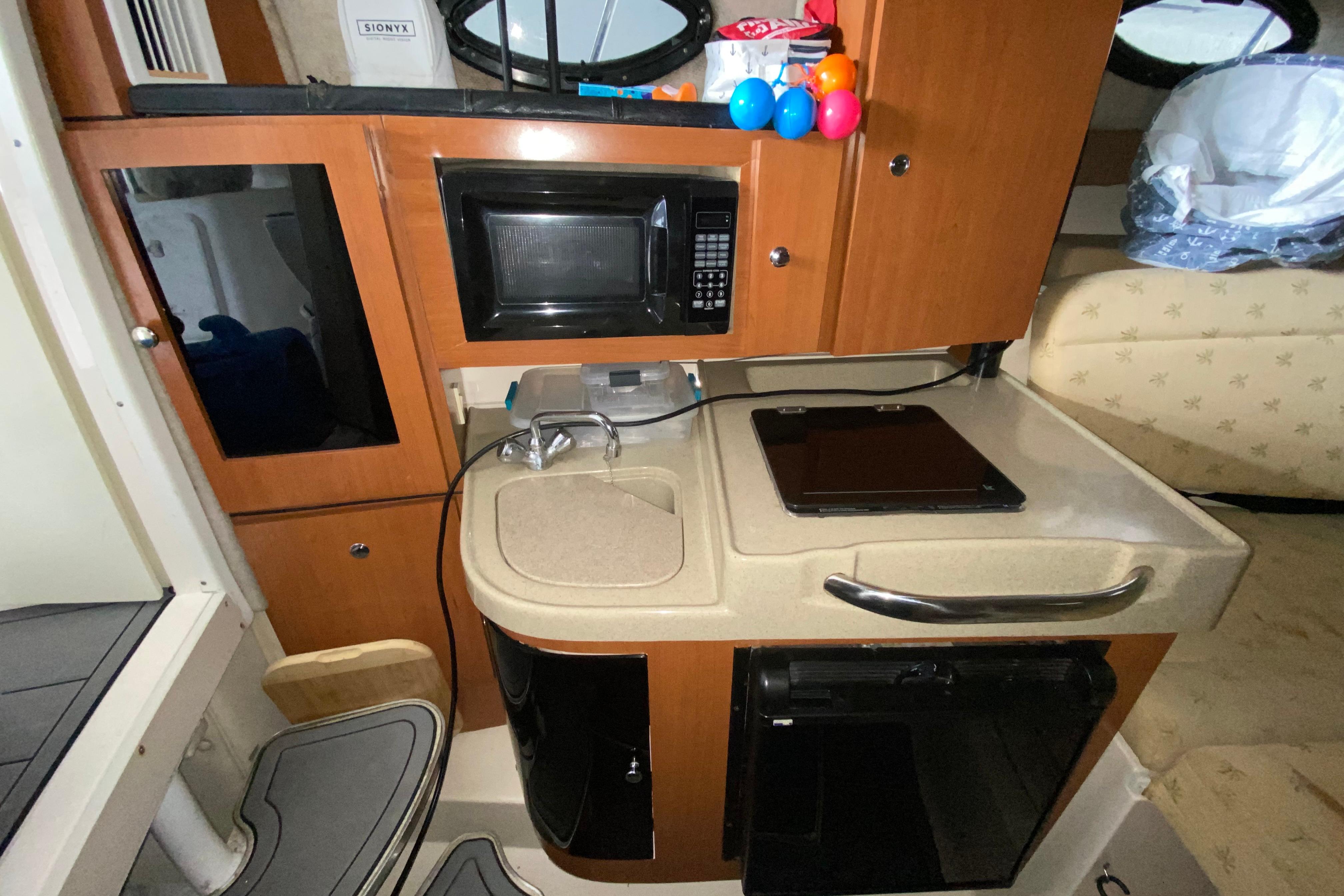 2005 Wellcraft 290 Coastal boat interior with kitchenette, microwave, and sink.