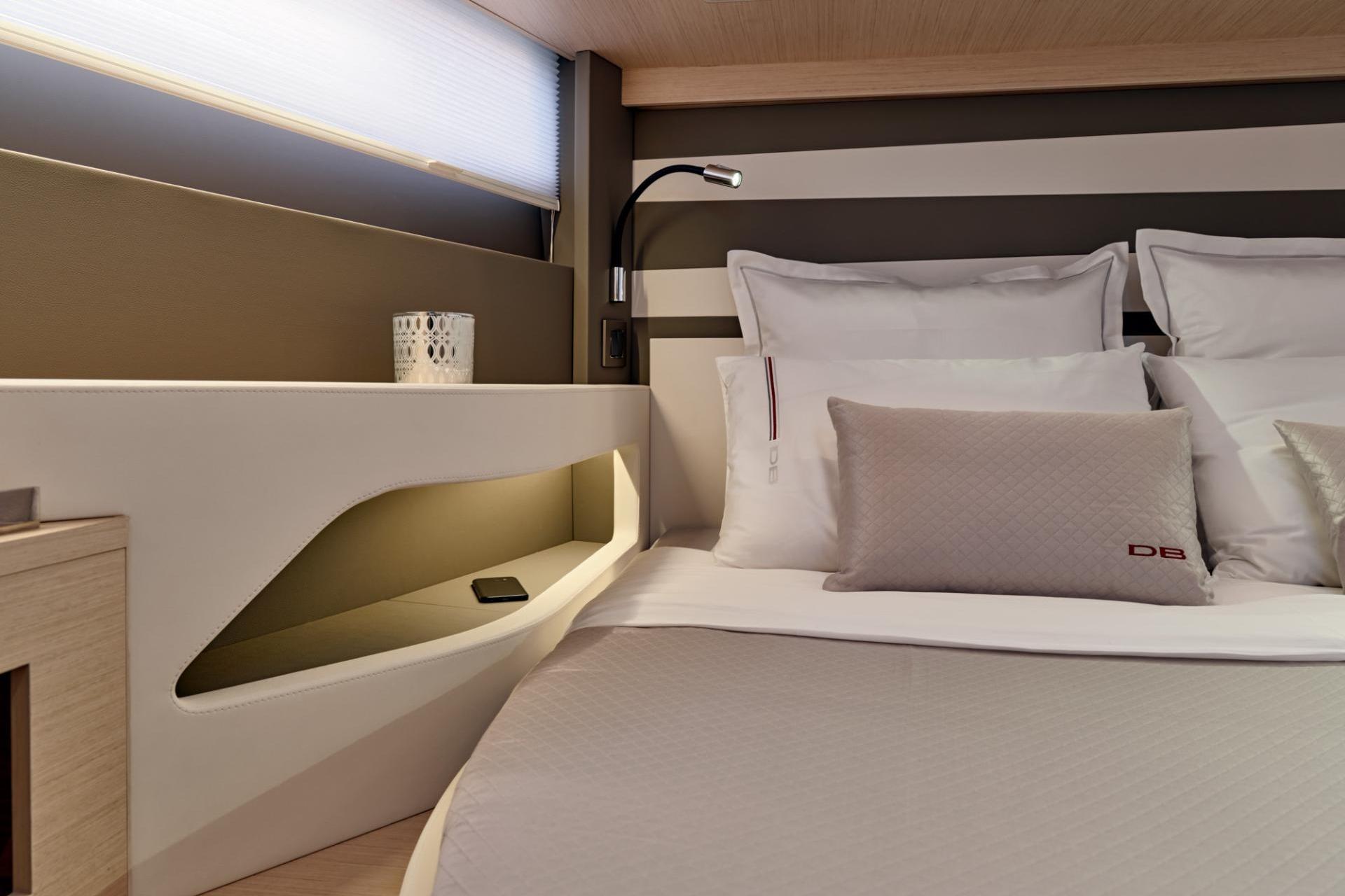 Luxurious cabin interior of 2027 Jeanneau DB/43 OB yacht with modern bedding and ambient lighting.