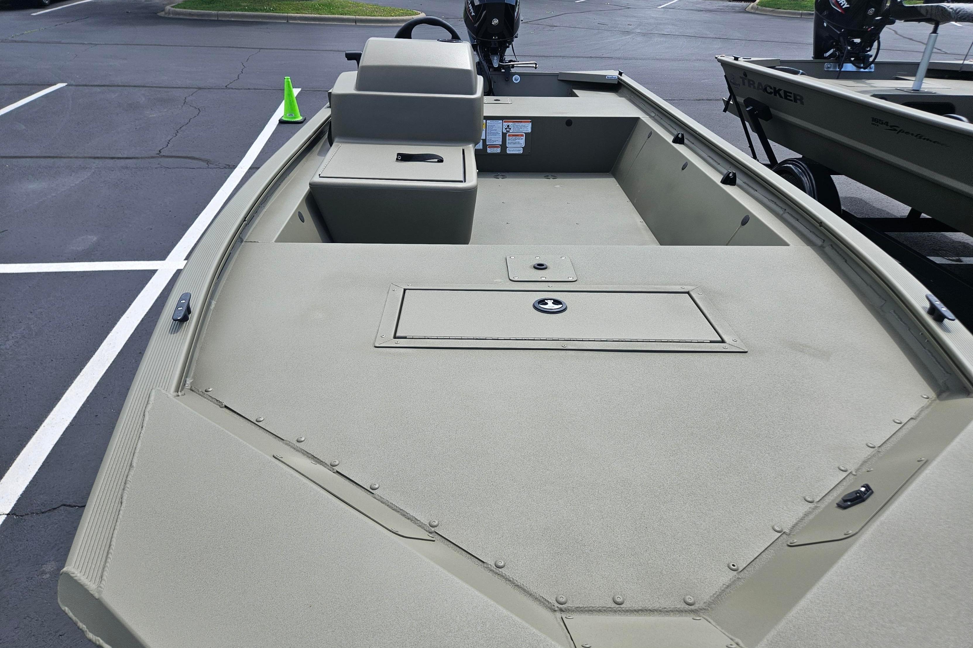 2026 Tracker Grizzly 1648 SC boat in parking lot, showcasing spacious deck design.