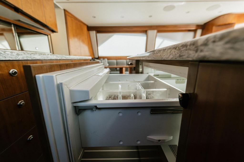 Luxury kitchen interior of 2021 Viking 58 Convertible yacht with open drawer.