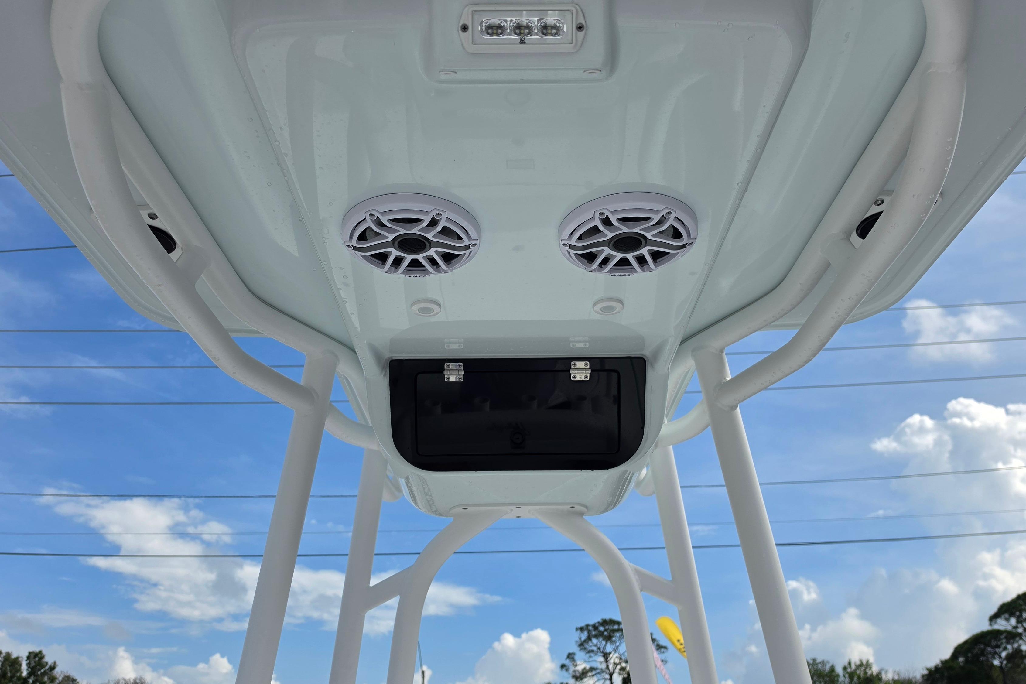 2026 Yellowfin 24 Bay CE boat T-top with speakers against blue sky.