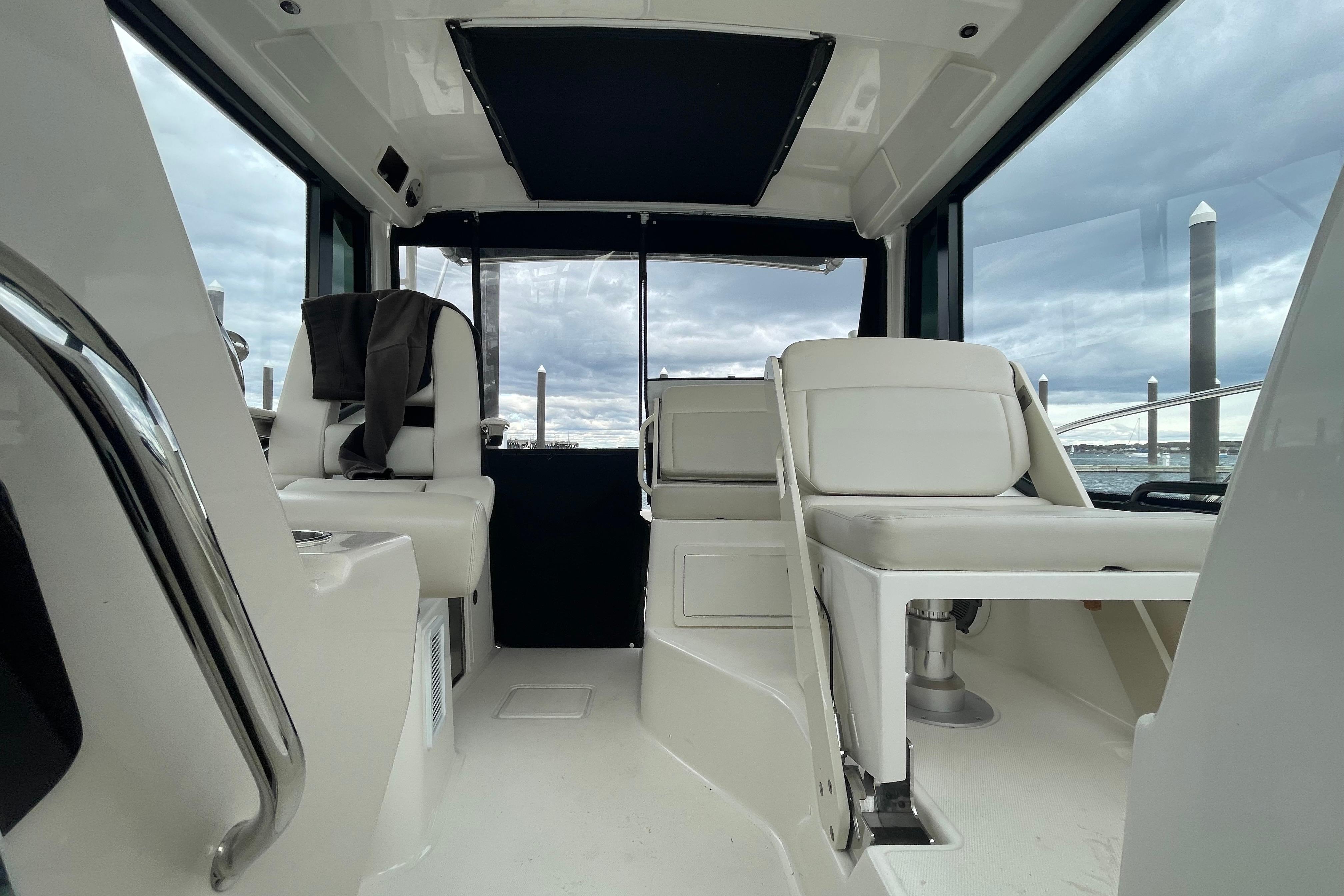 Interior of 2023 Boston Whaler 325 Conquest boat, featuring white seating and modern design.