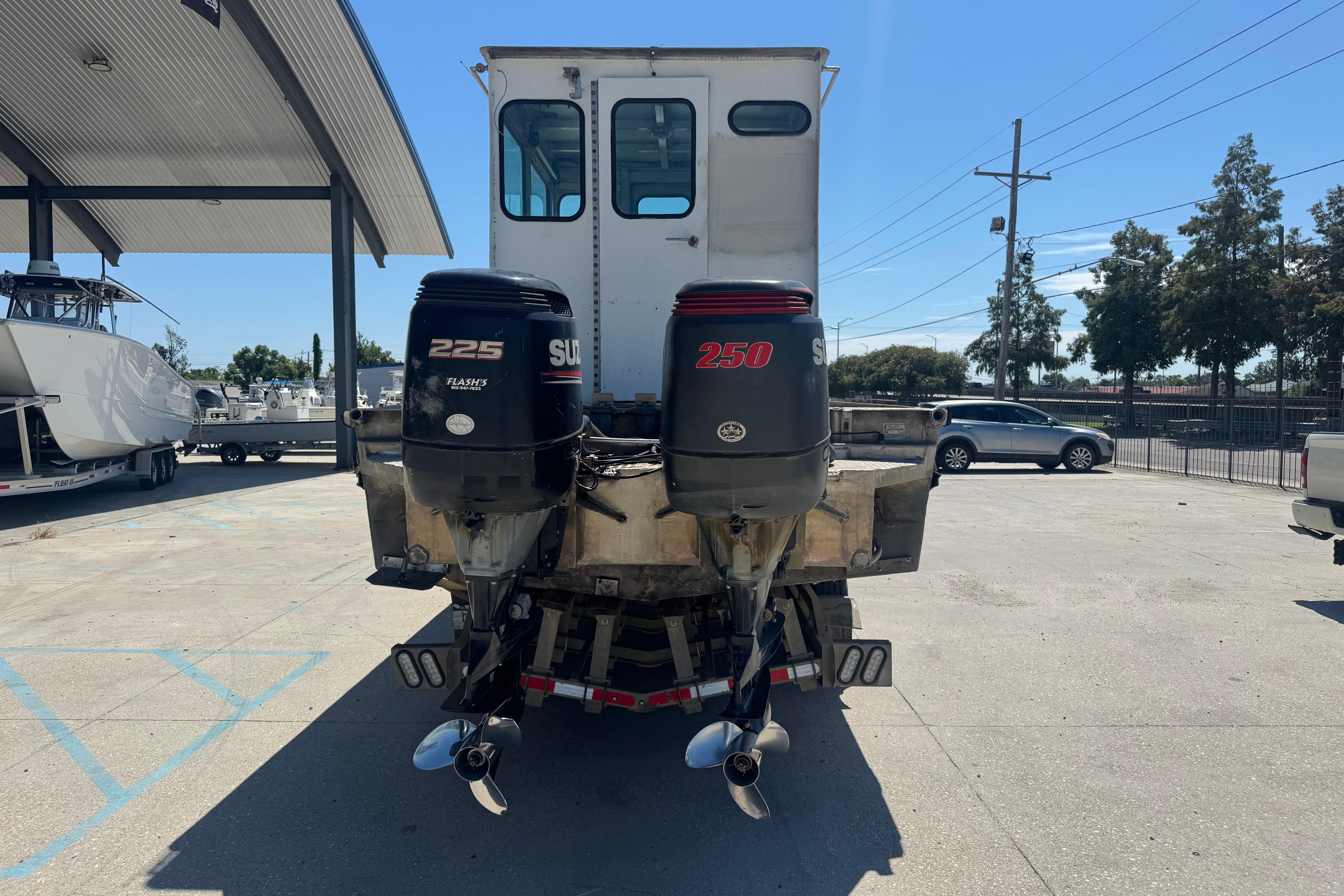 Custom Aluminum Work Boat 33, 2010 model, with dual outboard motors in a parking area.