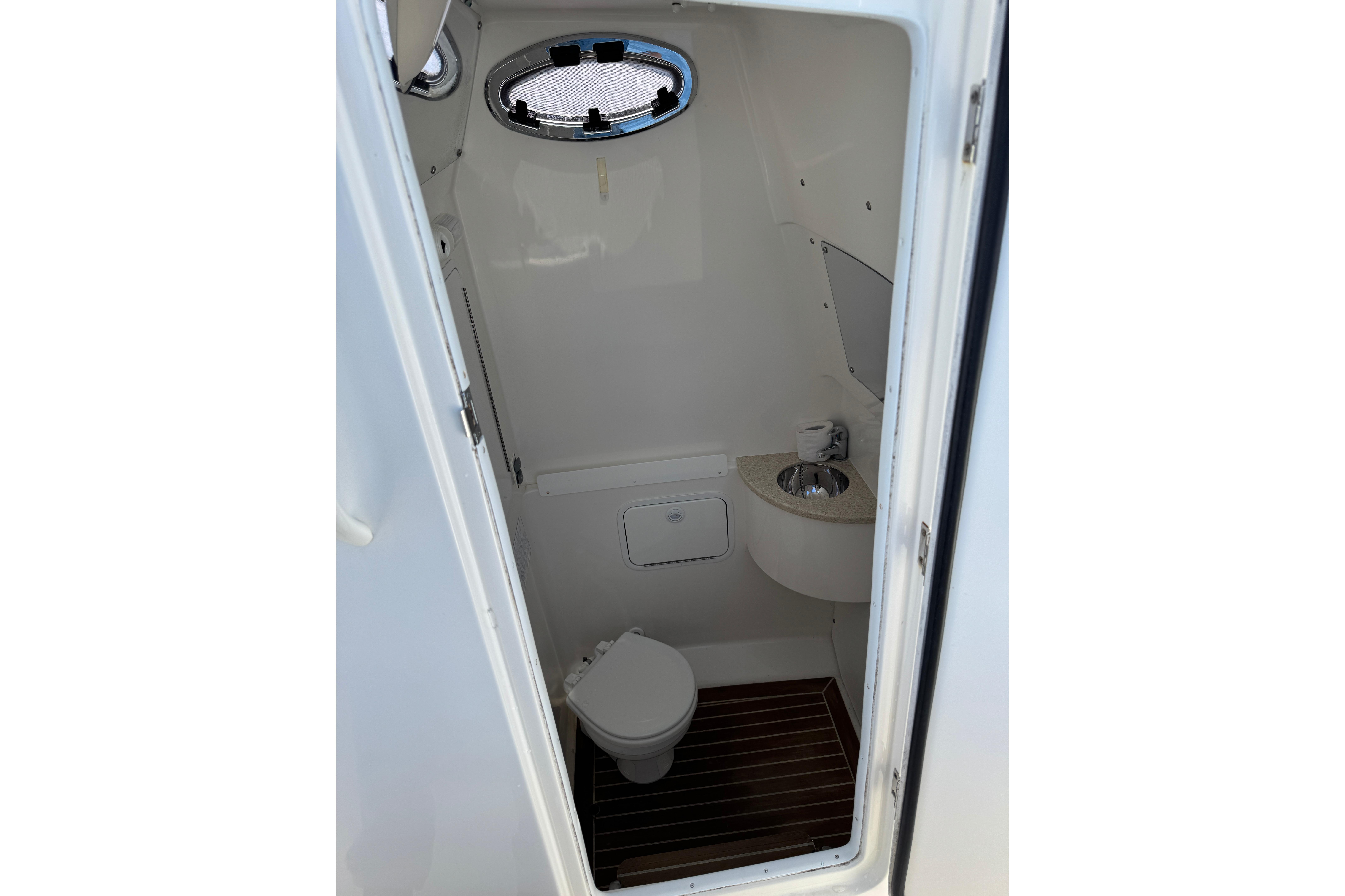 2015 Regulator 28 Forward Seating boat interior bathroom with toilet and sink.