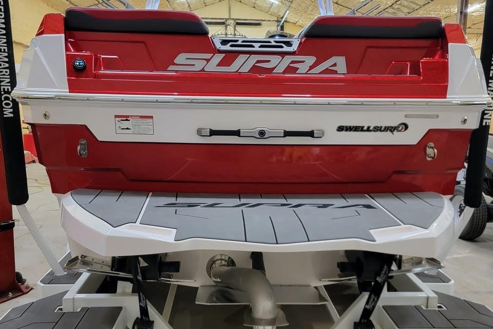 2023 Supra SE 550 boat rear view with SwellSurf technology, red and white design.