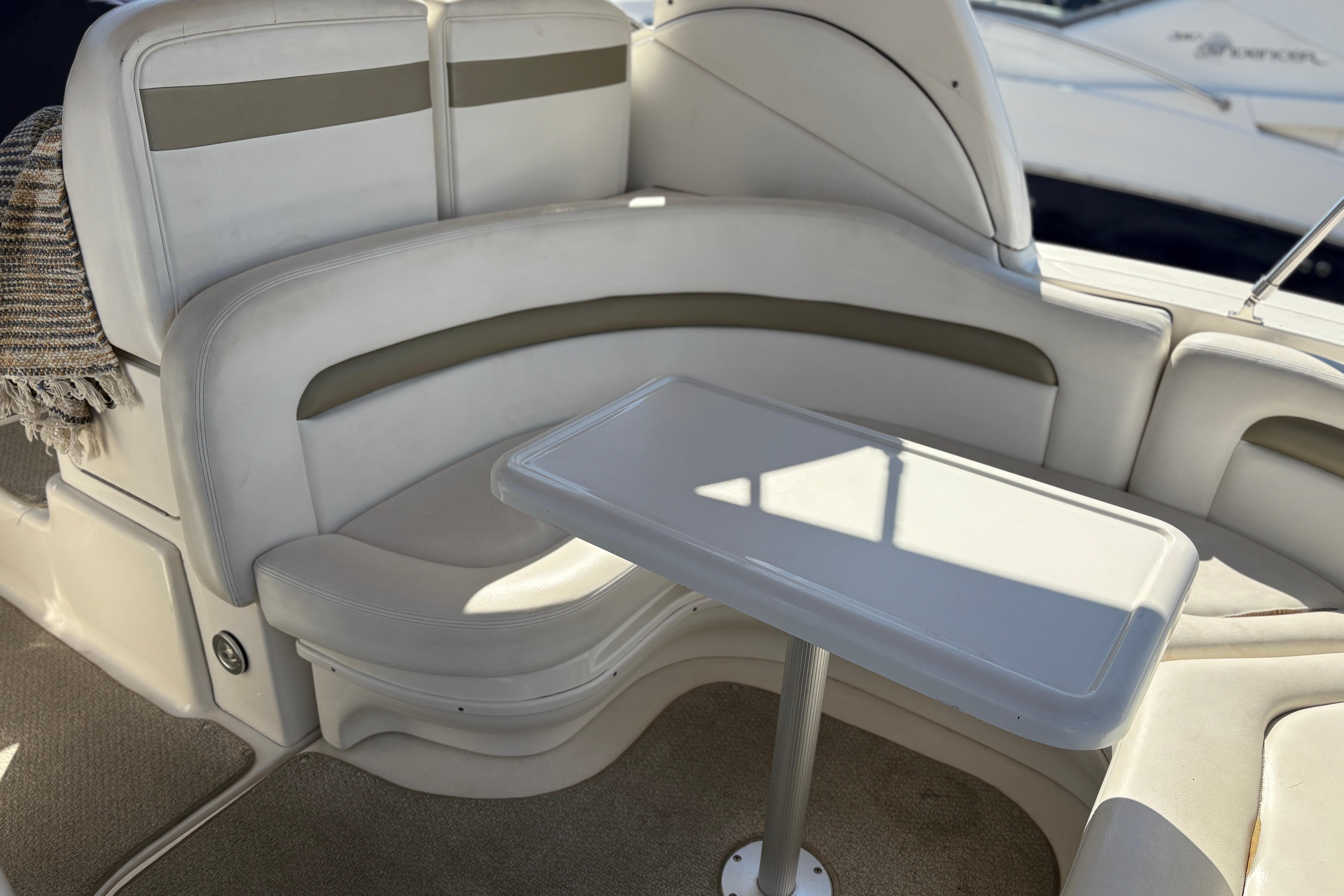 Luxurious seating area on a 2006 Sea Ray 320 Sundancer yacht with a sleek table.