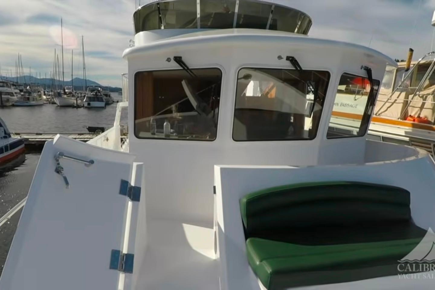 2003 Jefferson Pilothouse 53 yacht docked at marina, featuring sleek design and spacious deck.