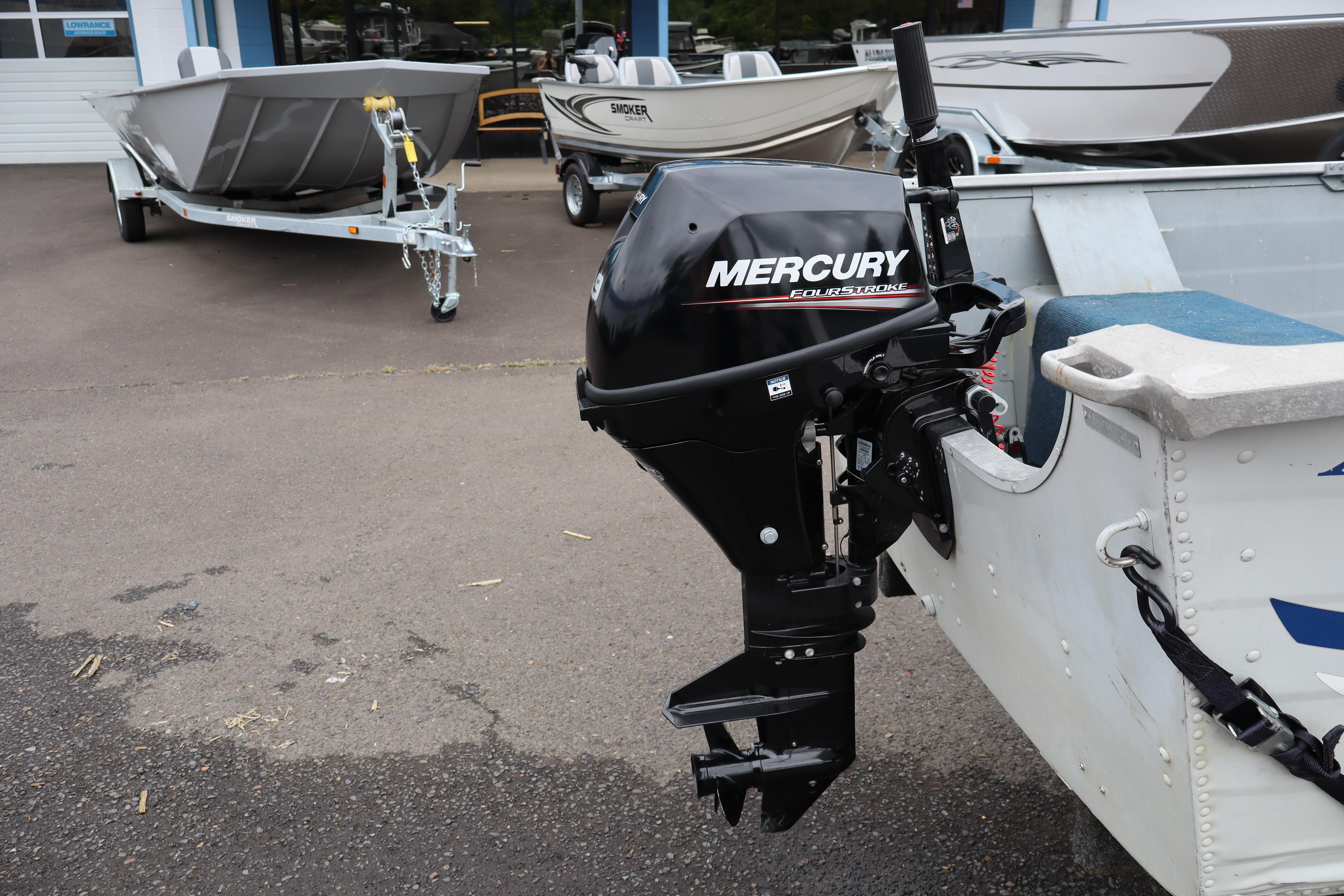 2003 Smoker Craft Alaskan 13 boat with Mercury FourStroke outboard motor in a dealership lot.