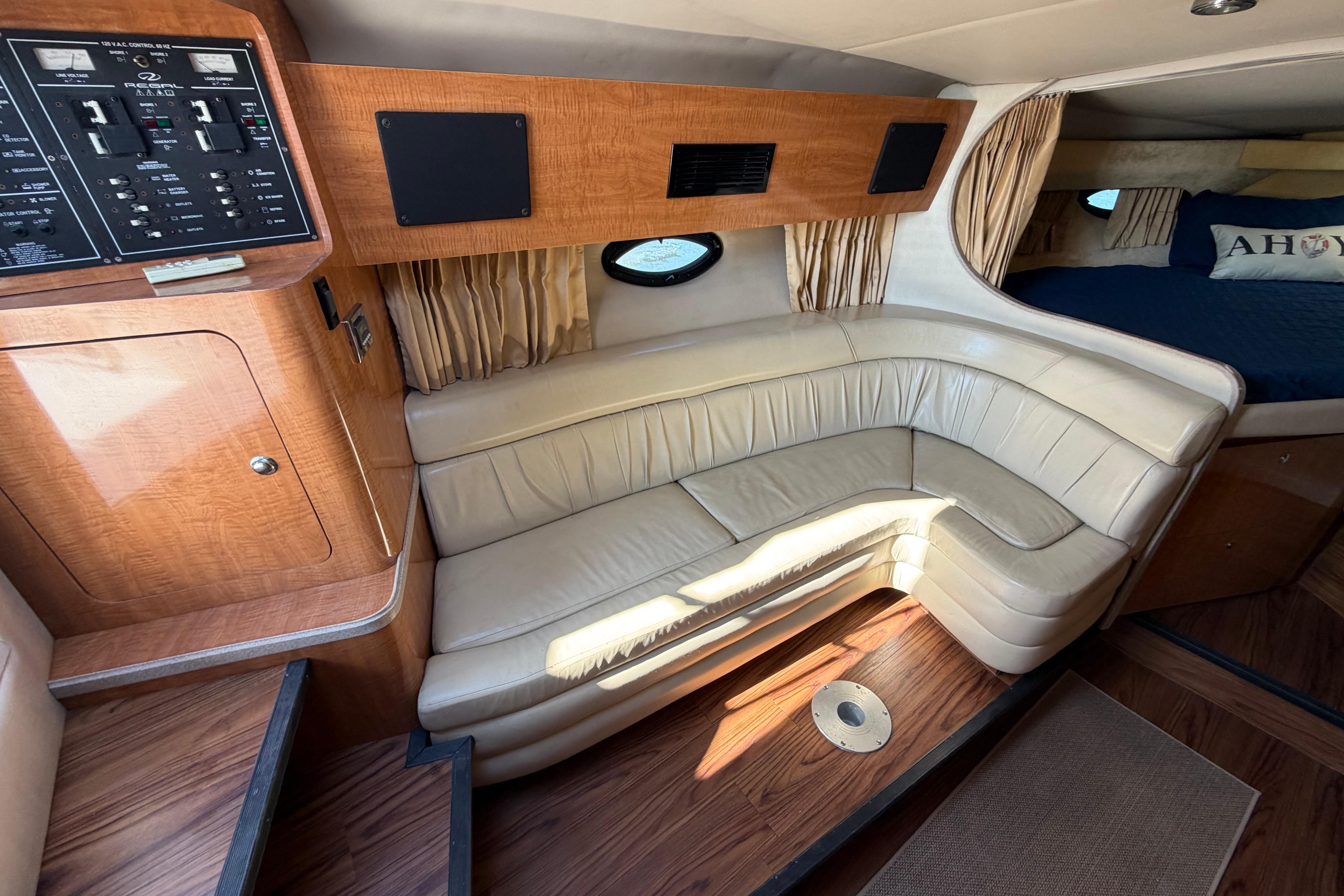 Interior of 2003 Regal Commodore 3260 yacht with leather seating and wood paneling.