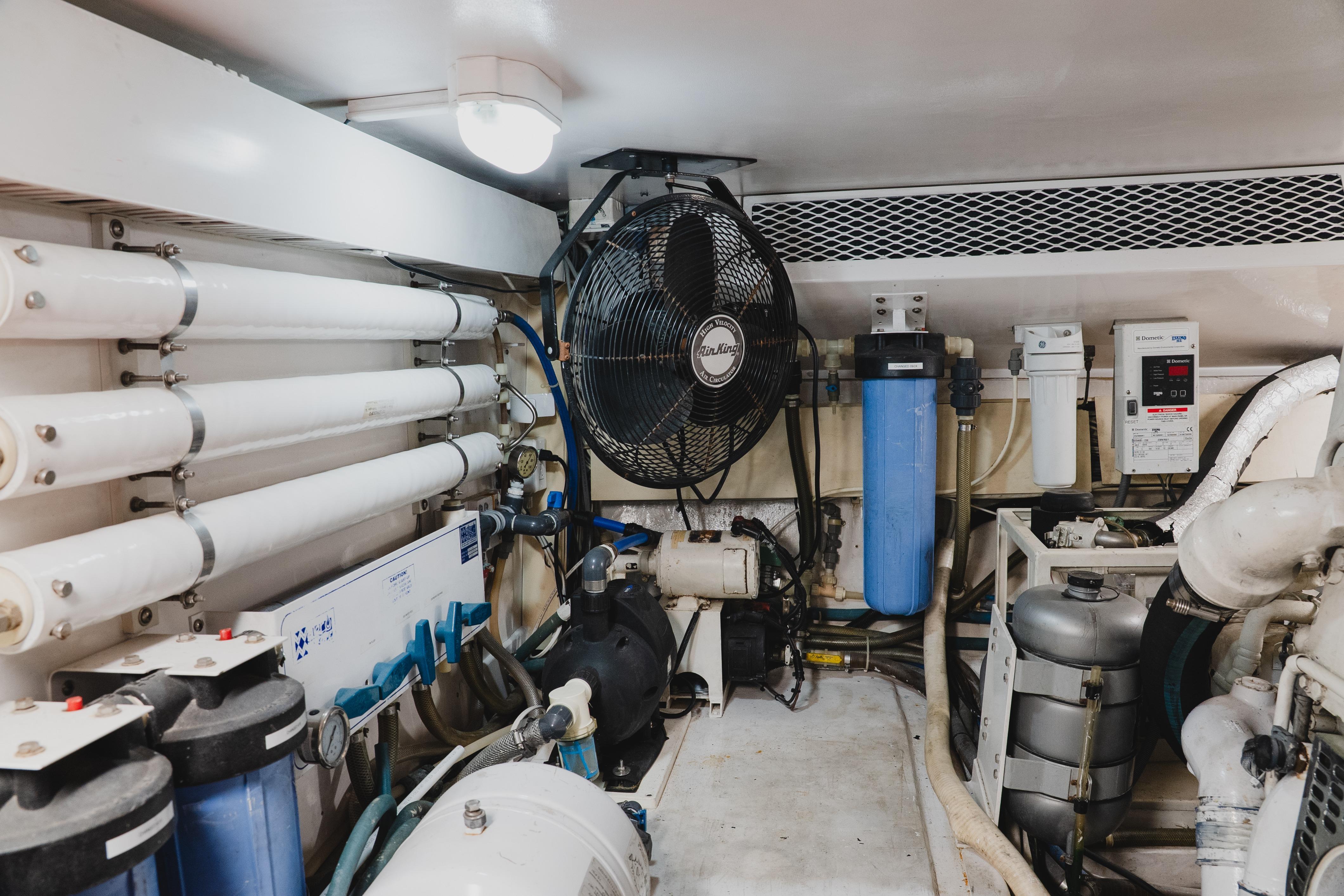 Engine room of a 1999 Viking 58 Convertible yacht, featuring filtration systems and machinery.