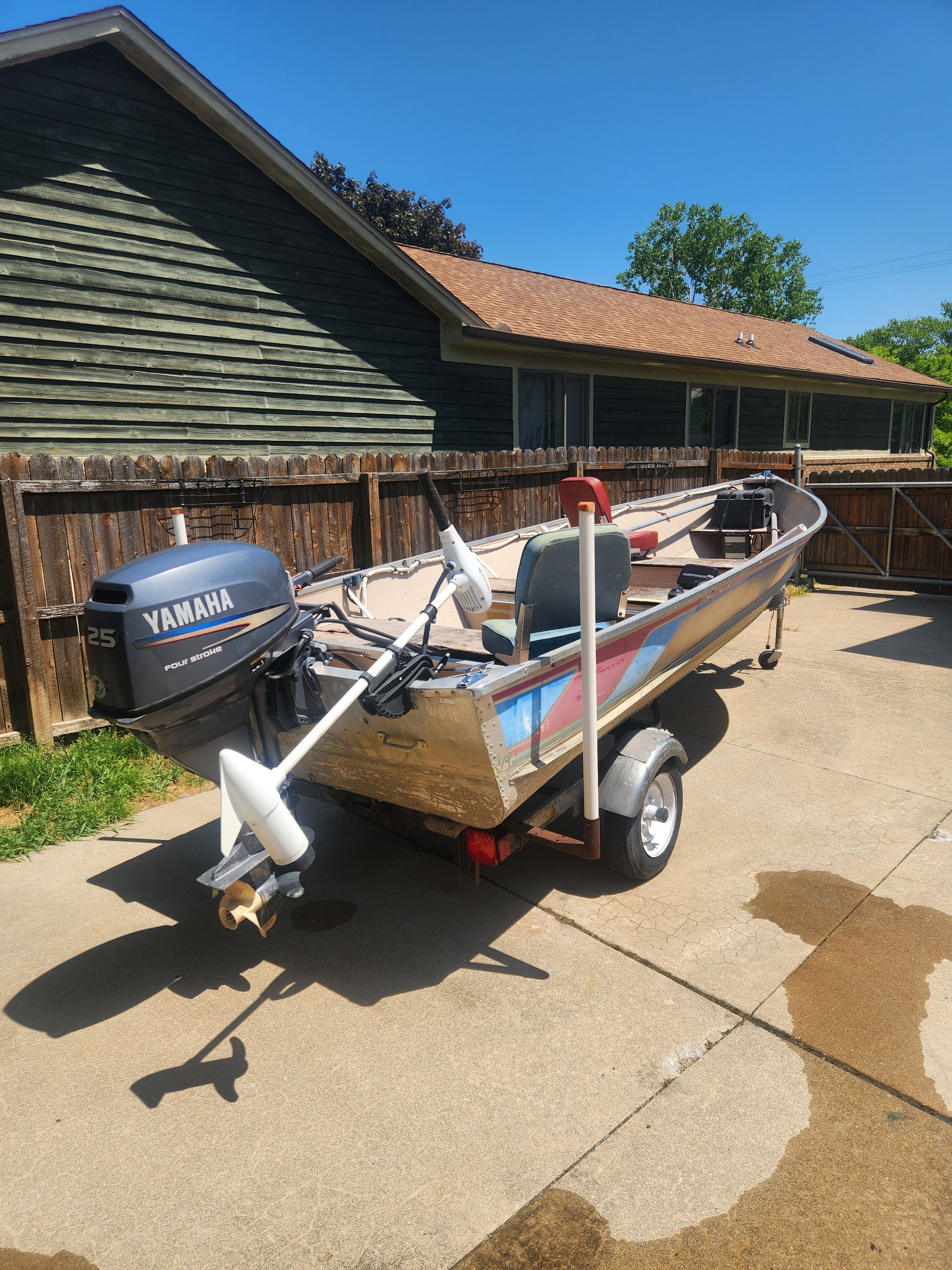 A 1998 Misty River Deep V boat on a trailer in a driveway.