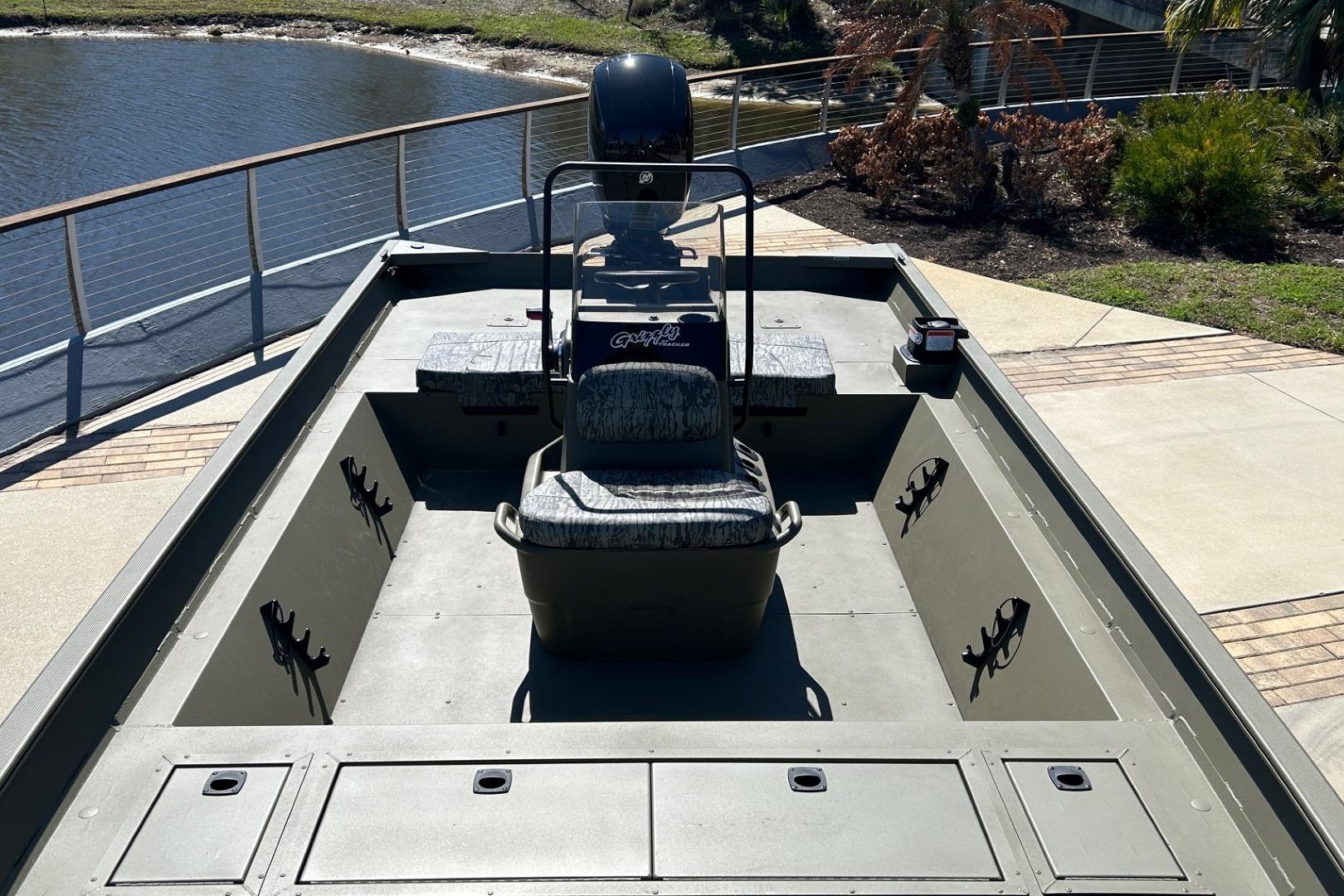 2026 Tracker Grizzly 2072 CC boat docked by a scenic waterfront.